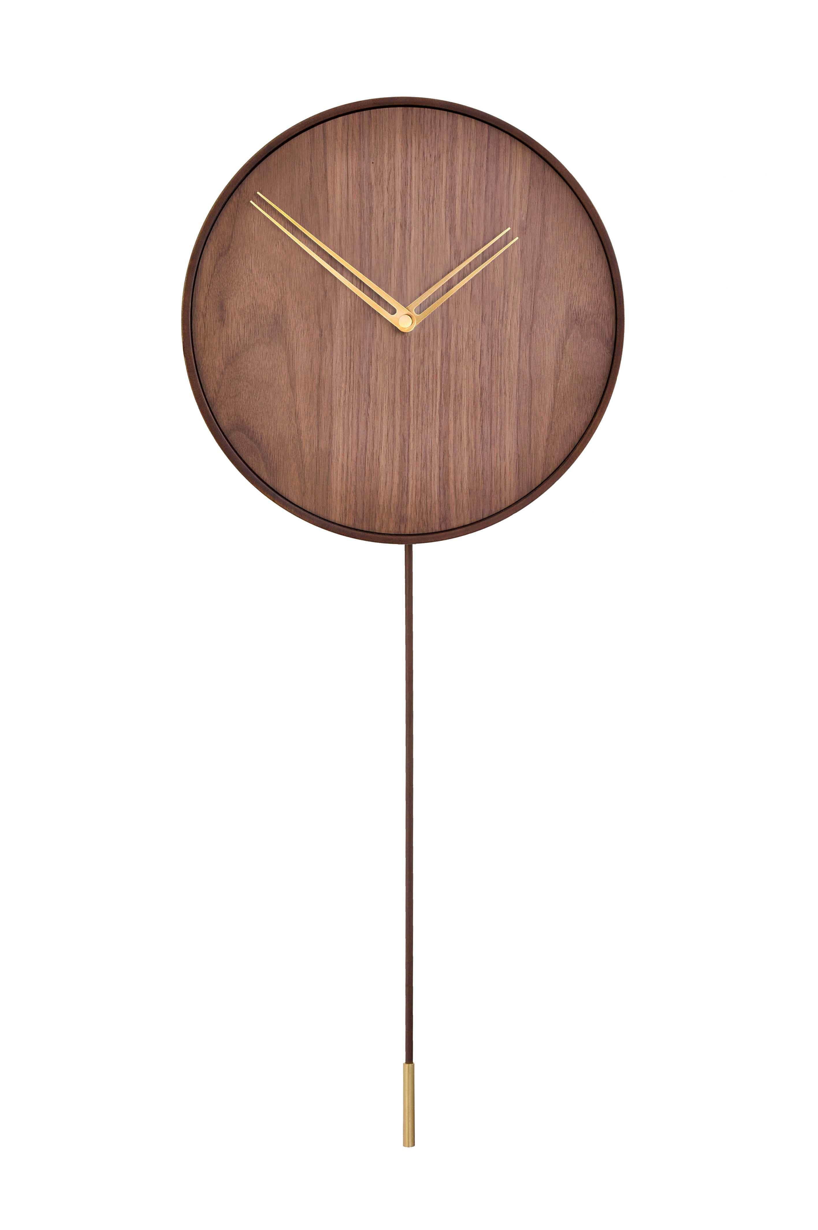 Parmi les montres tendance et avant-gardistes proposées par la marque Nomon, figure l'horloge murale Swing G. Il présente un design innovant utilisant des tons sombres de noyer et des aiguilles d'or. Il fait partie de la collection Gold N qui se