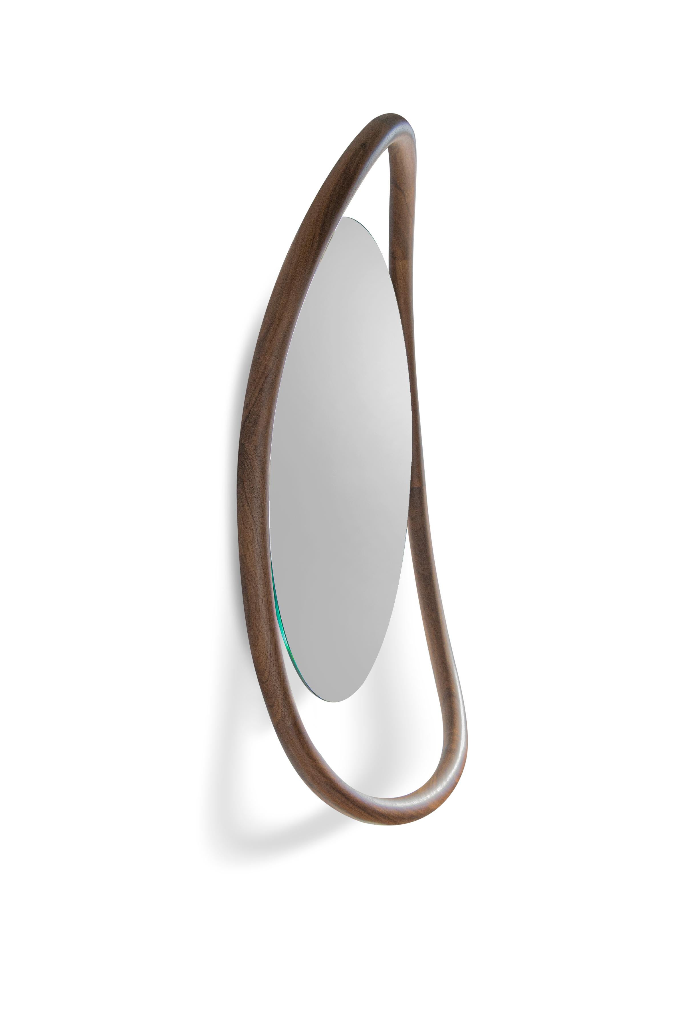 The singularity of this mirror is based on its caring proportions.
Two options with floor-standing mirror or wall-mirror; a hand-made natural walnut shelf combines the softness lines of the mirror.

Available in 
Walnut
Black Stained Ash