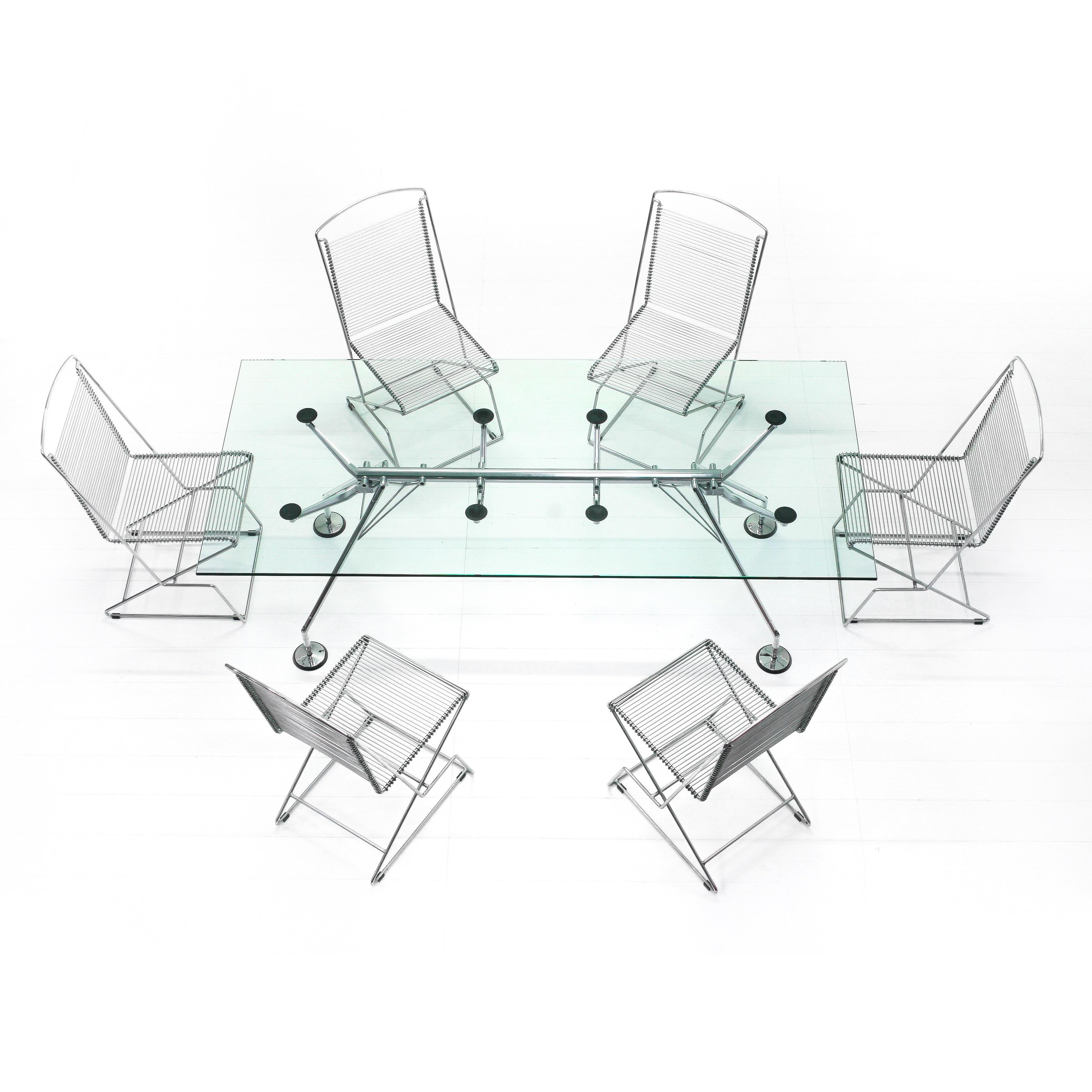 Table with chromed metal base and glass top; the Nomos table designed by Norman Foster was winner of the prestigious 'Compasso d'Oro' in 1987, it is a table that is striking for its unique structure and zoomorphic aesthetics, the solid skeleton has