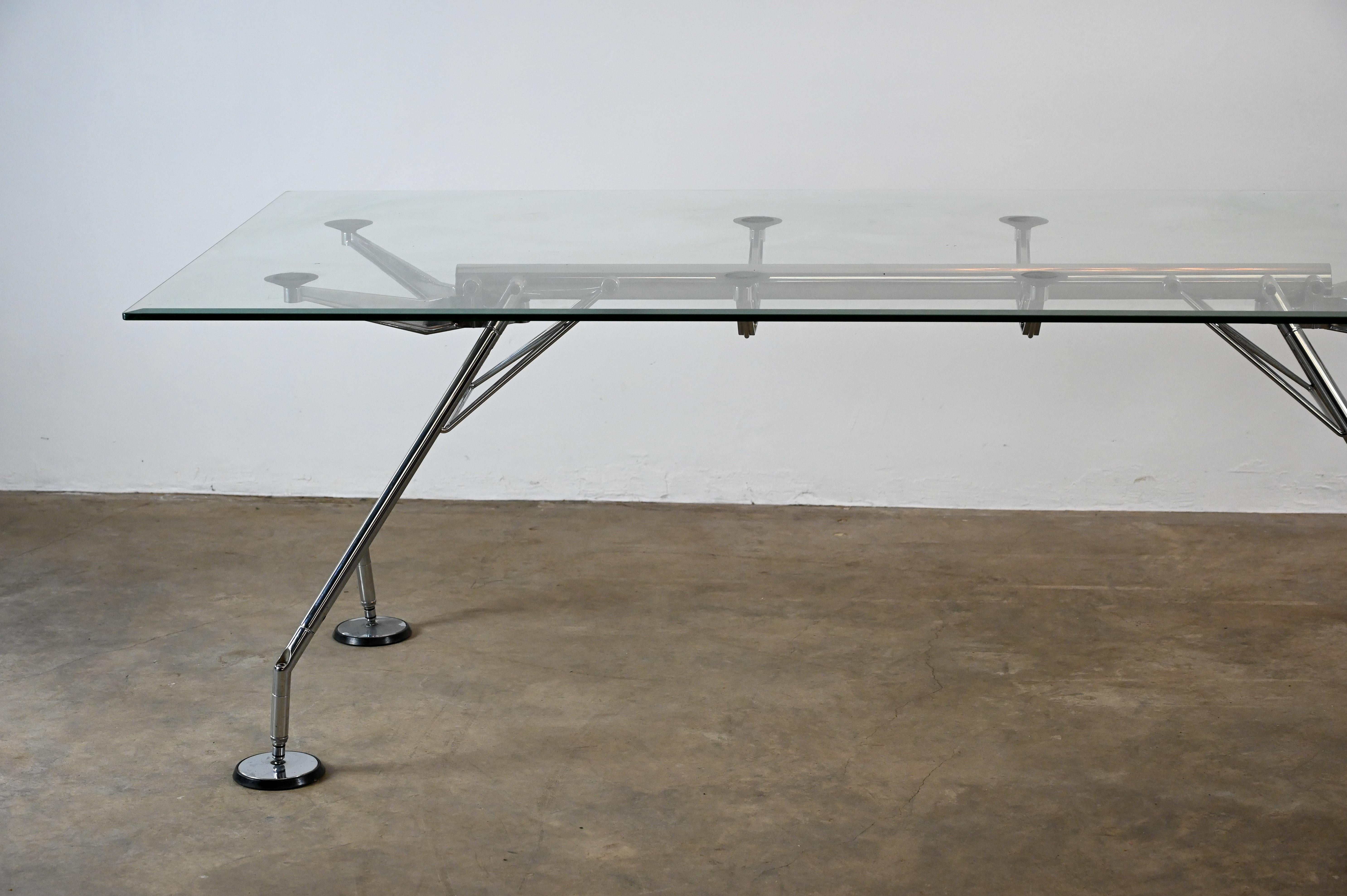 Élevez votre espace avec l'élégance intemporelle de la table en verre Norman Foster, modèle Nomos, méticuleusement fabriquée par Tecno, Italie. Conçu par le célèbre architecte Norman Foster, ce chef-d'œuvre incarne un mélange harmonieux de forme et