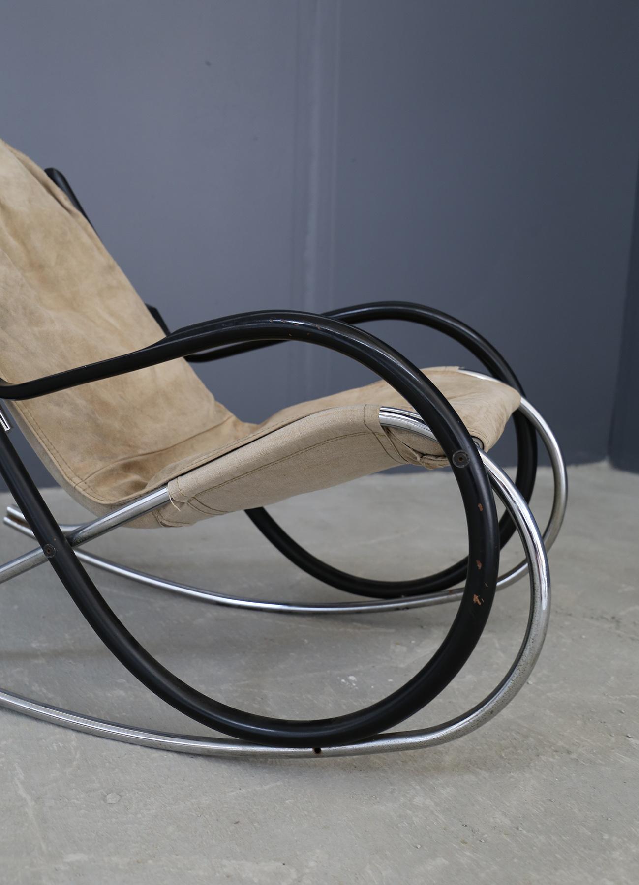 Comfortable Nonna rocking chair designed by Paul Tuttle for Strassle international, Switzerland 1972. This example is very nice with the tubular chrome rocking frame and the sides in black lacquered curved wood. Seat in buckskin canvas in very good