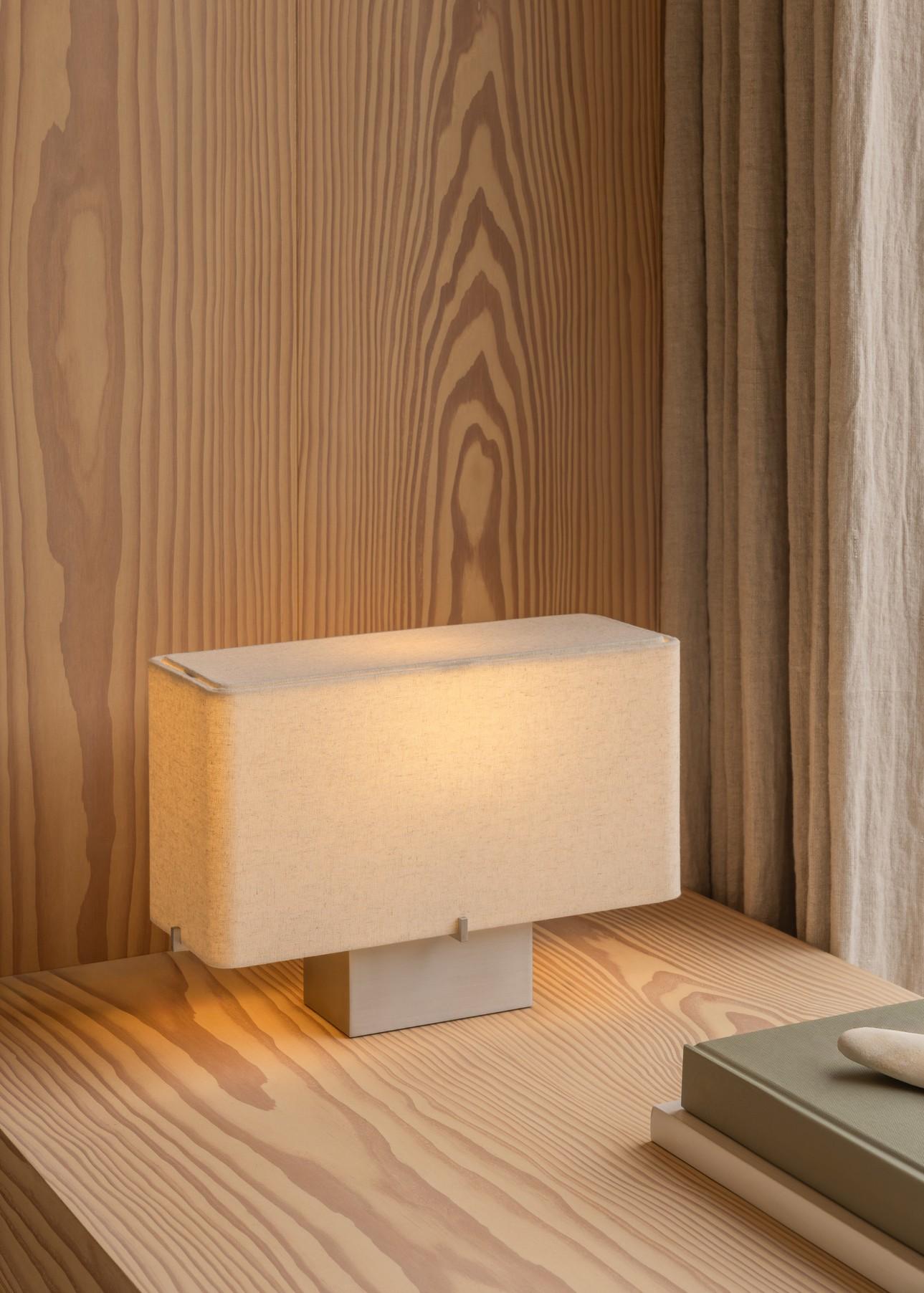 Light in scale yet grounded in presence, the H24 Nonna Table Lamp pairs a subtly textured sand-colored textile shade with a cool brushed aluminum base. Designed for narrow ledges and intimate spaces, it offers a quiet contrast between softness and