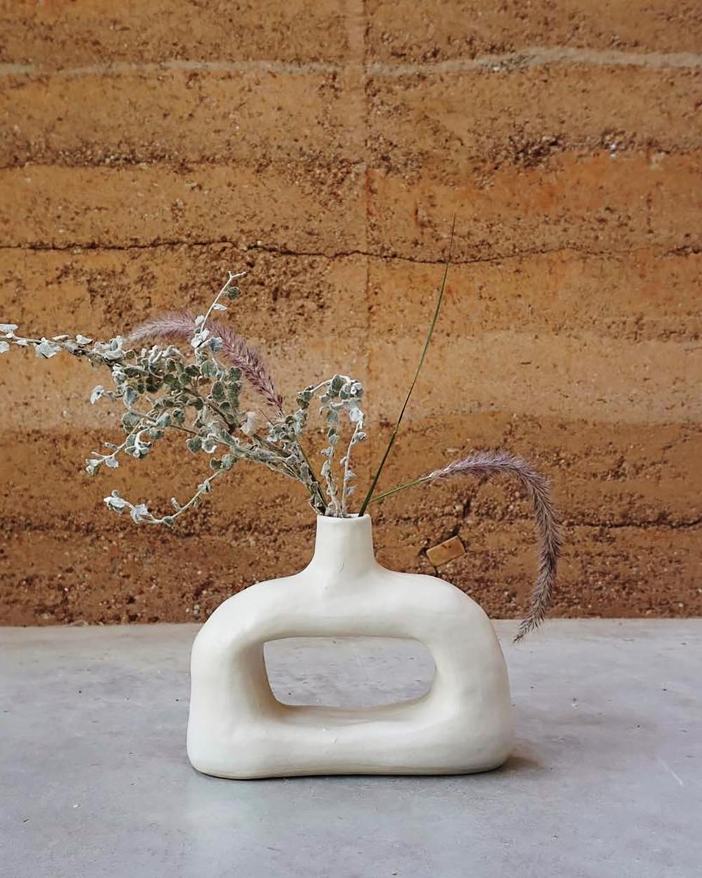 Il vaso di argilla Nook è un pezzo senza tempo realizzato con argilla bianca naturale. Realizzato a mano con materiali naturali e dalla forma rustica e scultorea, offre un look organico e moderno che incarna un'estetica di lusso minimalista e