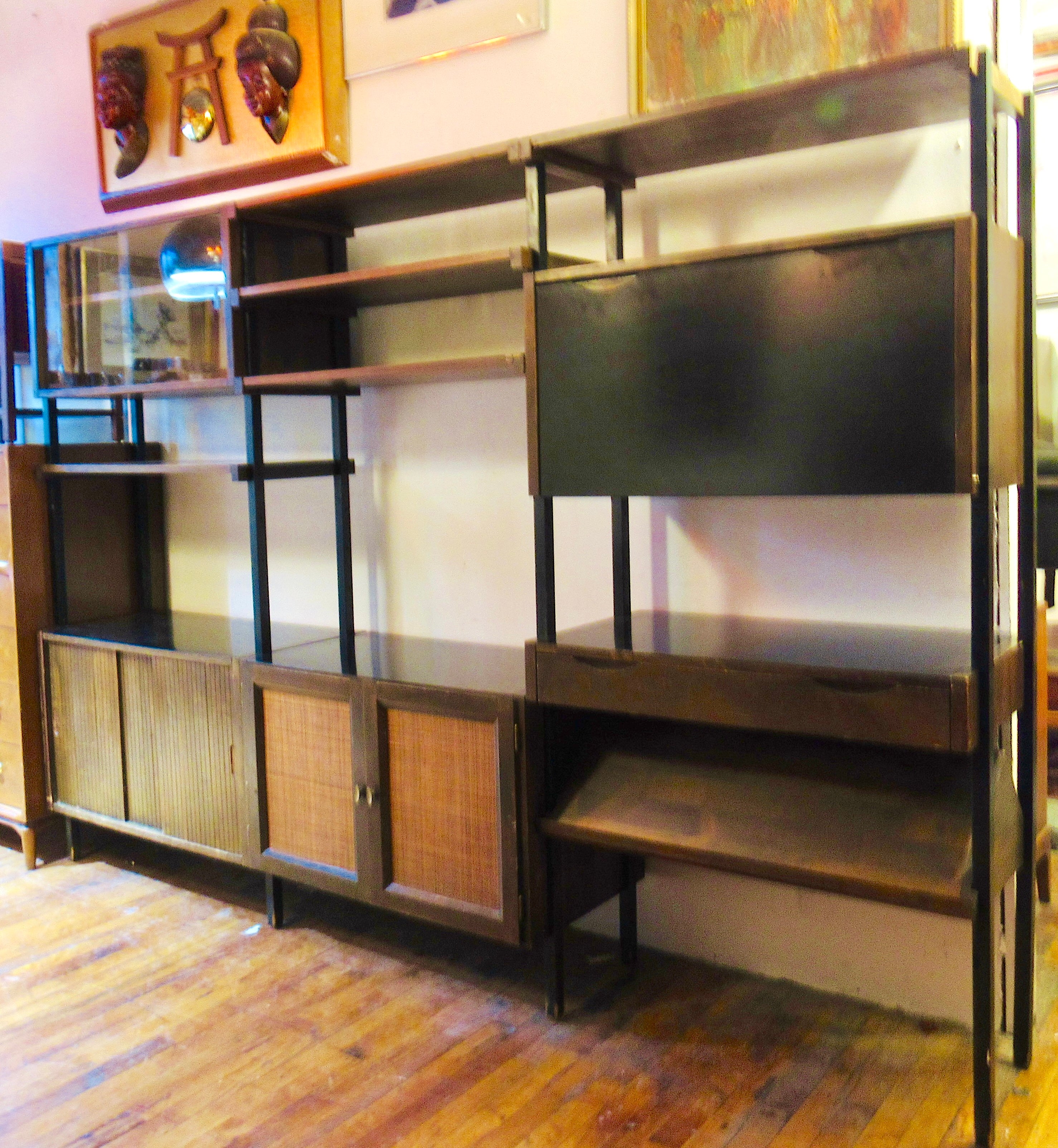 Grande parete attrezzata di Noral Olson per Kopenhvn, con tre librerie agganciabili. Ogni libreria in piedi è dotata di armadietti e scomparti unici in noce con accenti in laminato nero e ante frontali a canne. Un sacco di spazio per la casa o