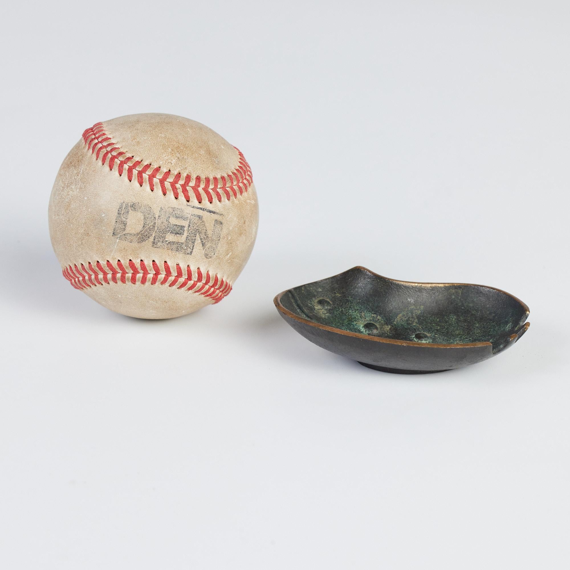 A solid bronze ashtray with 3 impressed places to lay an object . It has a textured interior with decorative details to resemble the form of a leaf. This piece has a beautiful verdigris finish.

Marked on the underside - Nordia - Made in