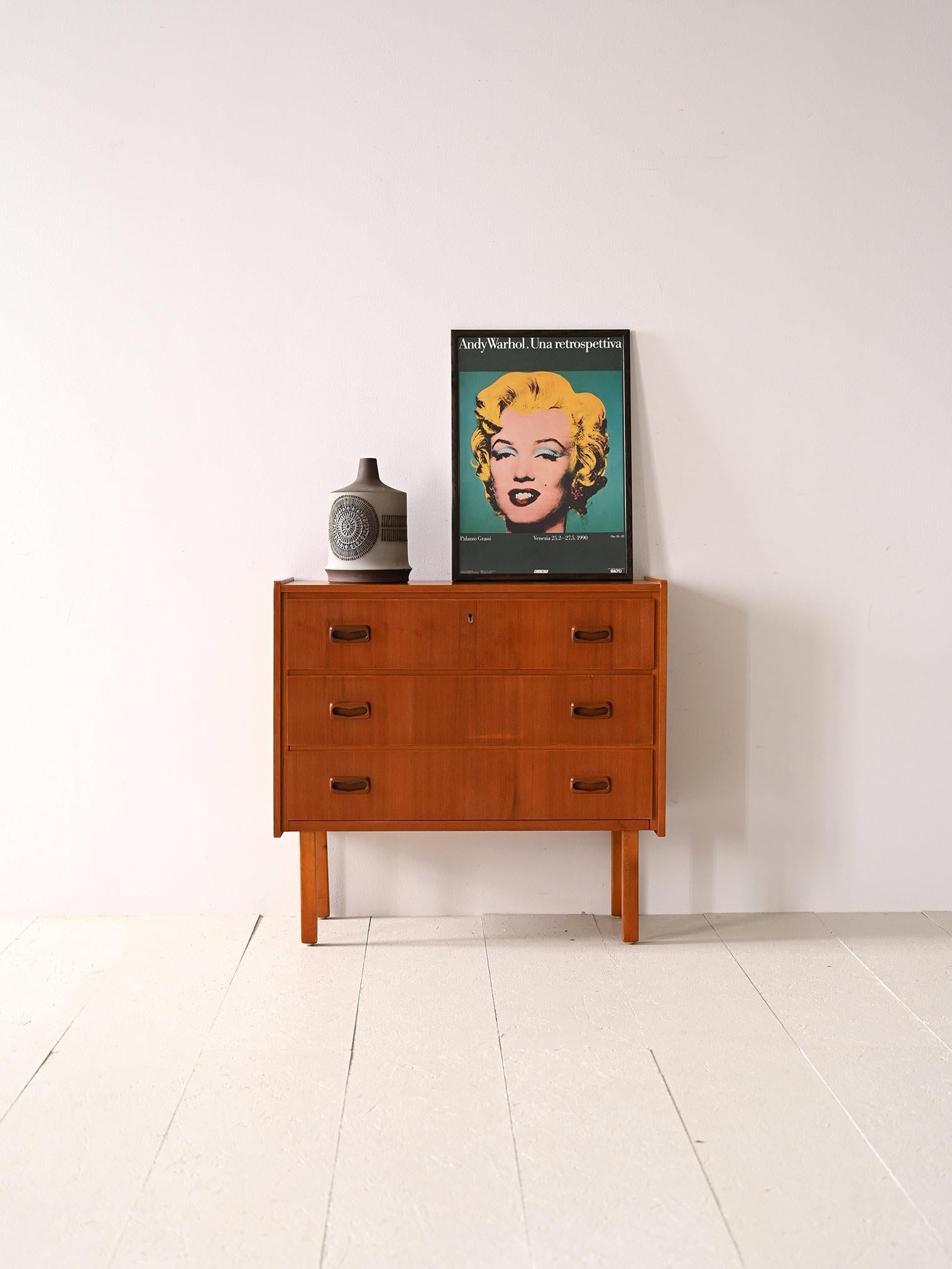 Vintage teak chest of drawers from the 1960s.
This Scandinavian design piece with clean and simple lines features three spacious drawers, perfect for storing everyday items such as linens, accessories or clothes. The first drawer also features a