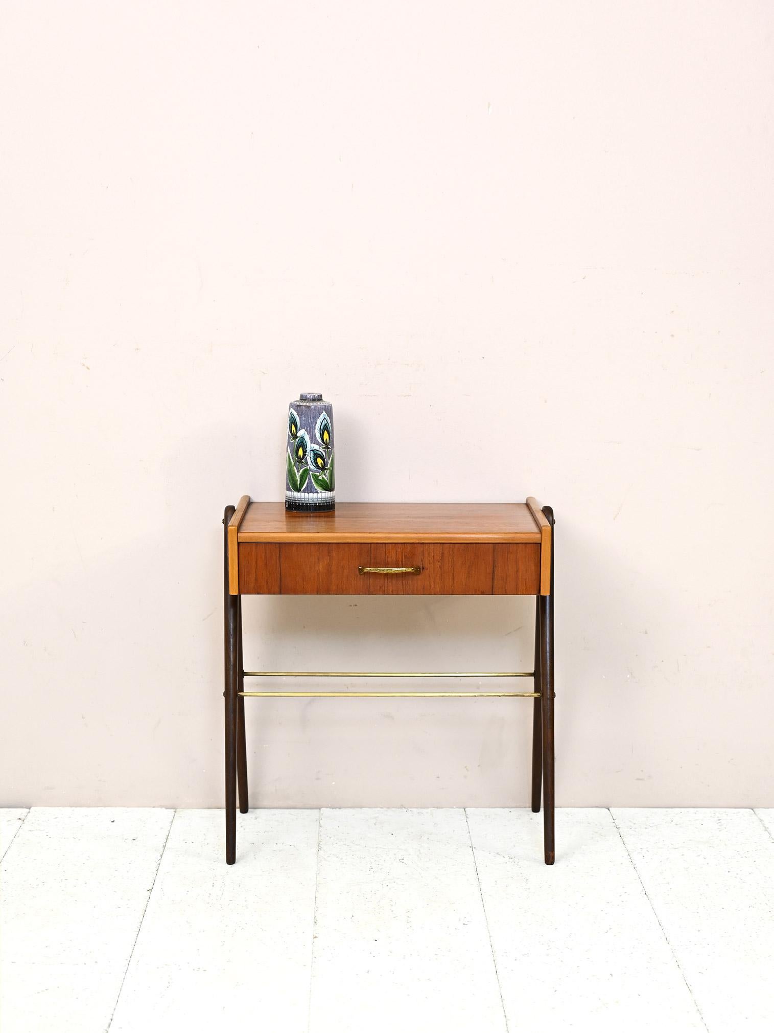 Vintage 1950s nightstand with drawer and magazine shelf.
 
Elegant and functional, this Scandinavian-made nightstand features modern lines and attention to detail.
 
The frame features V-shaped legs, a convenient drawer with brass handle and a
