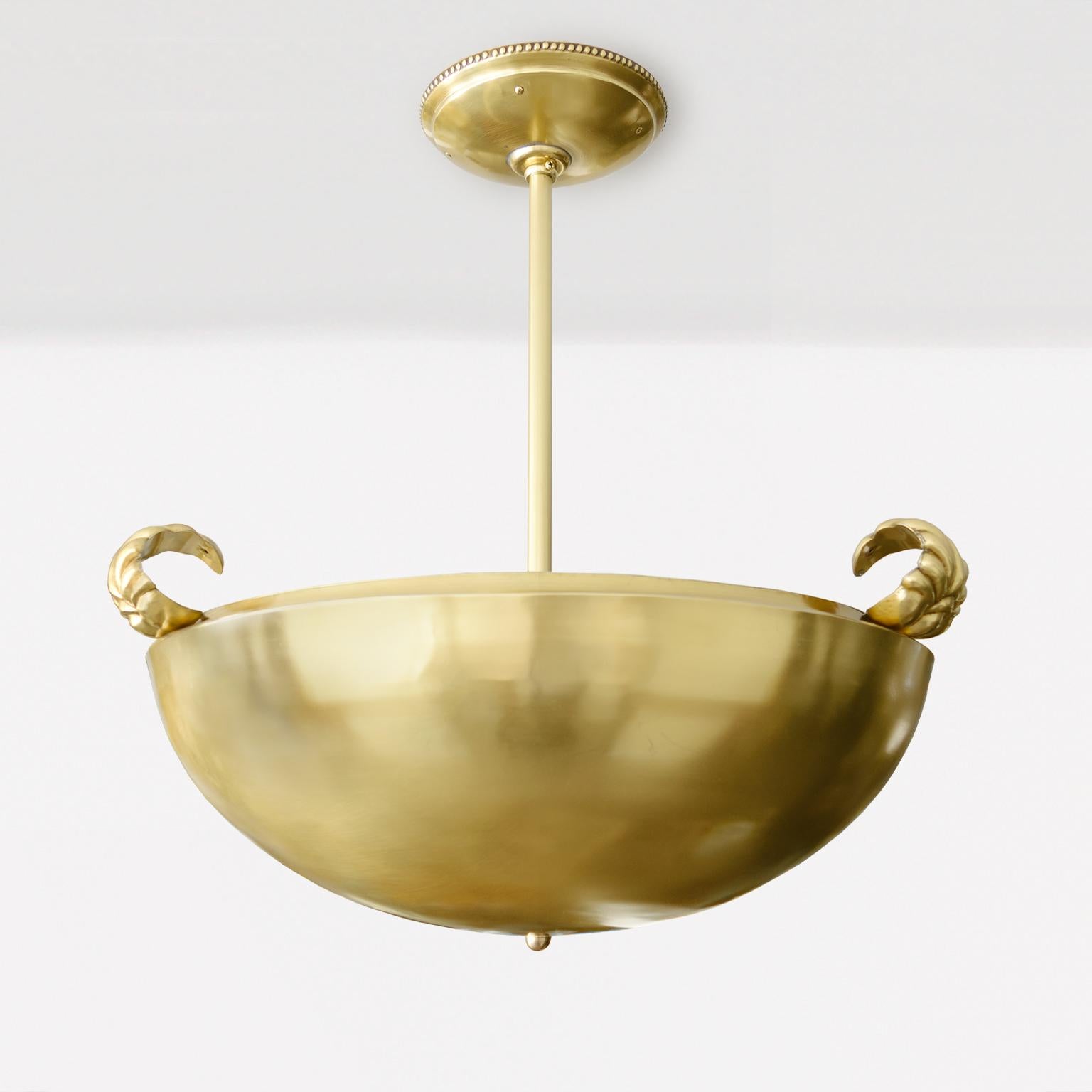 Nordic modernist polished brass pendent by Koru Helsinki, Finland 1925-30. The half sphere shape has a recessed upper rim which upon rest three robustly rendered, curled leaves. Inside the body is the original aluminum liner / reflector, along with