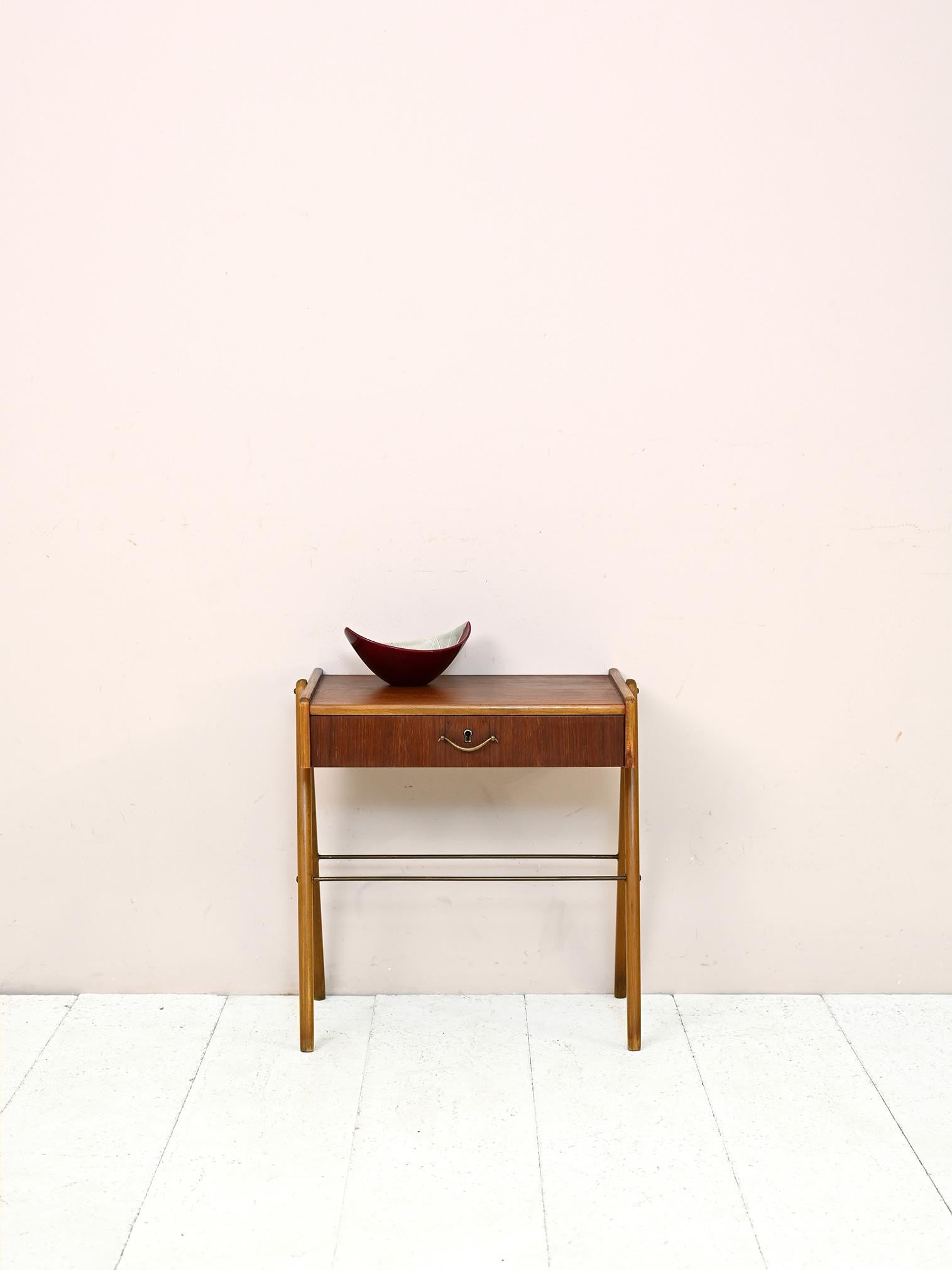 Vintage 1950s nightstand with drawer and magazine shelf.

Elegant and functional, this nightstand of Scandinavian manufacture features modern lines and attention to detail.

The frame features V-shaped legs, a convenient drawer with wooden