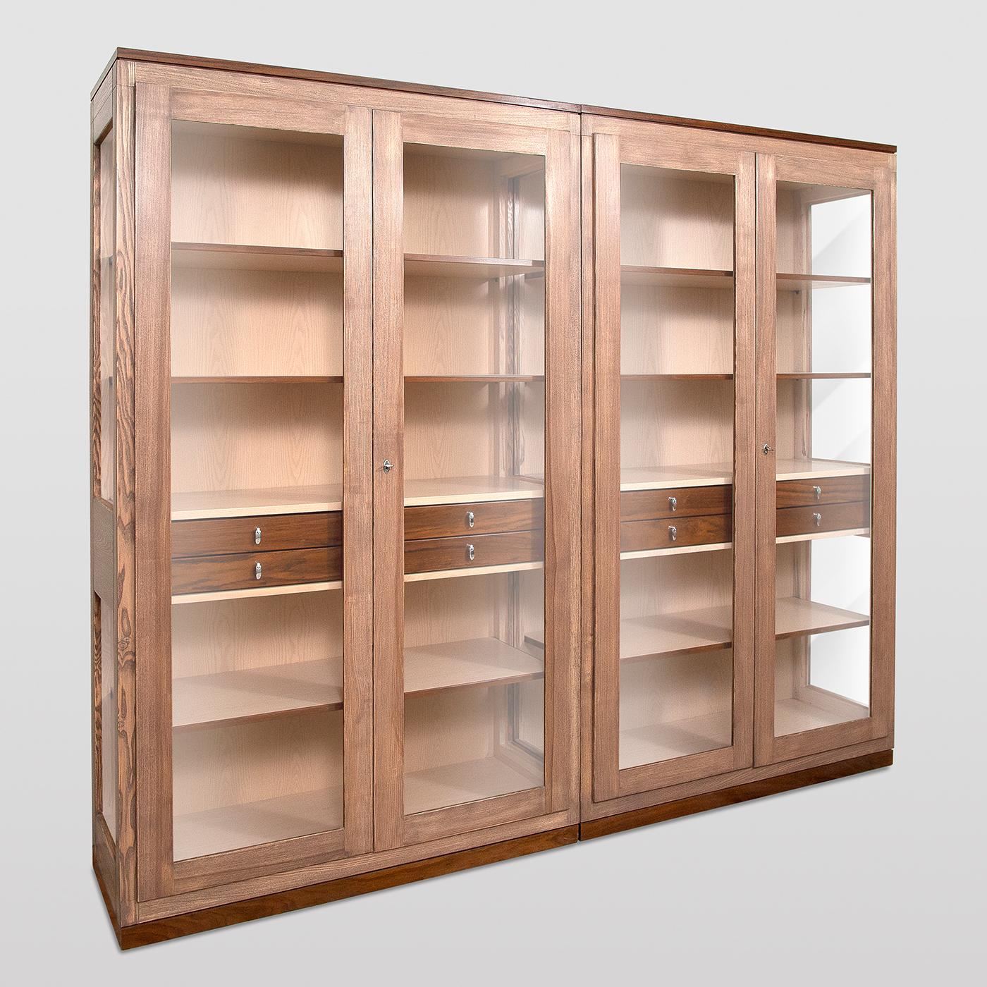 Designed by Erika Gambella, this modular bookcase flaunts a clean and functional shape typical of Nordic design. Furnished with eight internal drawers and six wooden shelves, it is handcrafted using high-quality techniques, adding to its refined and