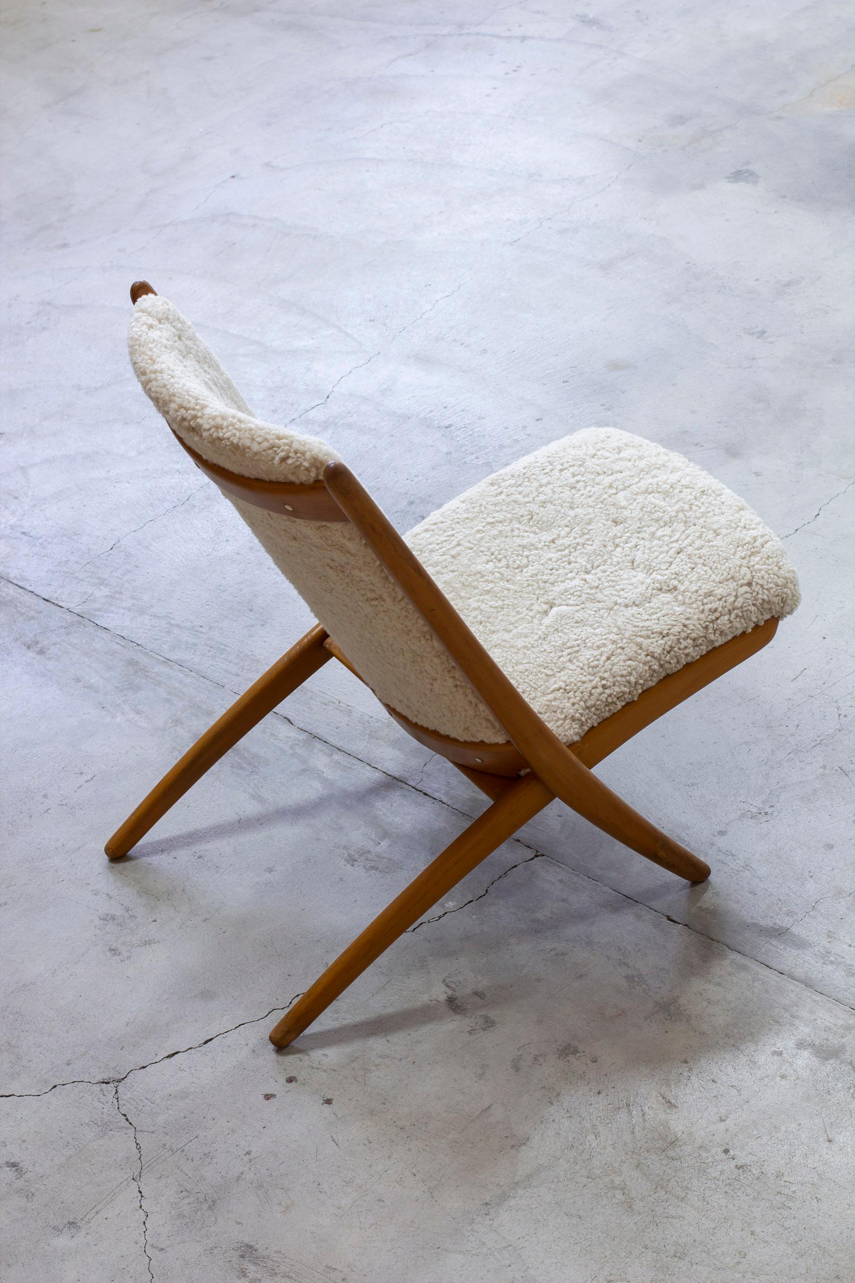 Demountable scissor style lounge chair, model Nordic. Designed by Ingmar Relling and produced in Norway during the 1950s by Vestlandske Stol og Møbelfabrikk. Frame made from stained lacquered beech with new sheep skin upholstery in cream color. Good