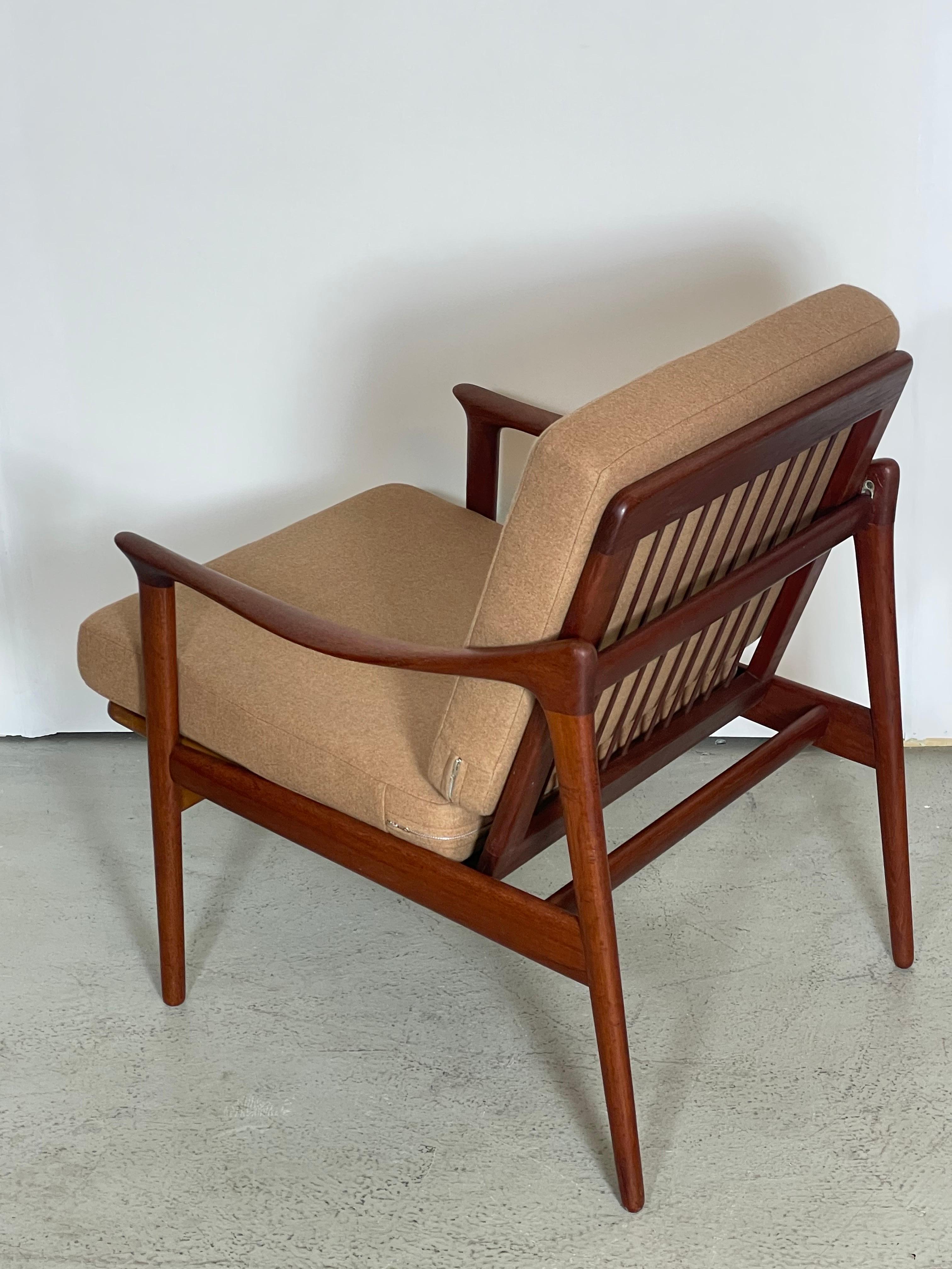 A brilliantly-conceived compact lounge chair in sculpted teak and cognac wool upholstery designed by Norwegian industrial designer Fredrik A. Kayser, 1950s. This frame features a completely demountable construction, with the two side assemblies