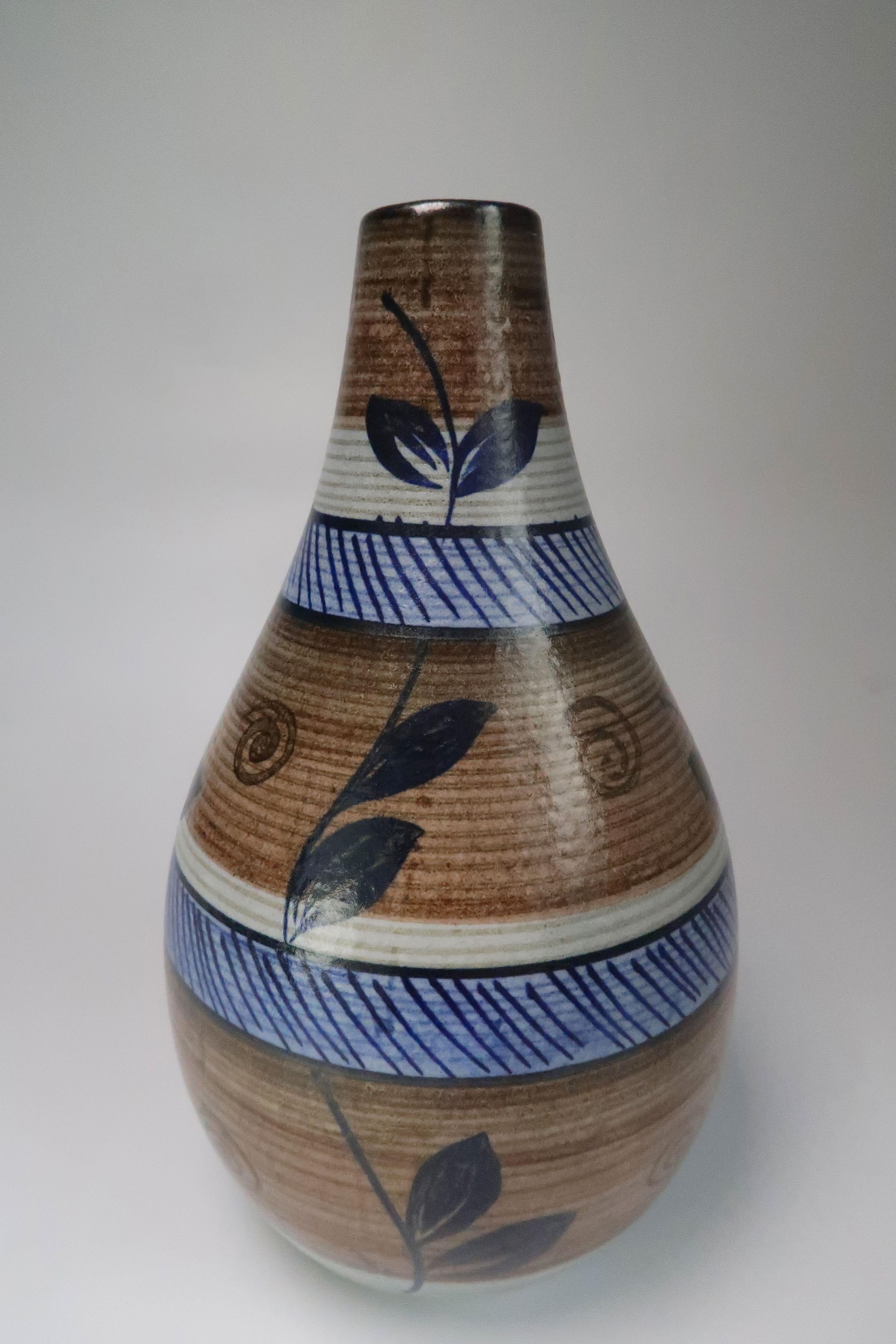 Swedish Mid-Century Modern hand painted vase by Rörstrand in the 1960s. Organic colors and decorations. Cedar and light oak brown, grey stripes, light and navy blue stripes, and dark blue vines with leaves from base to top. Stamped and signed under