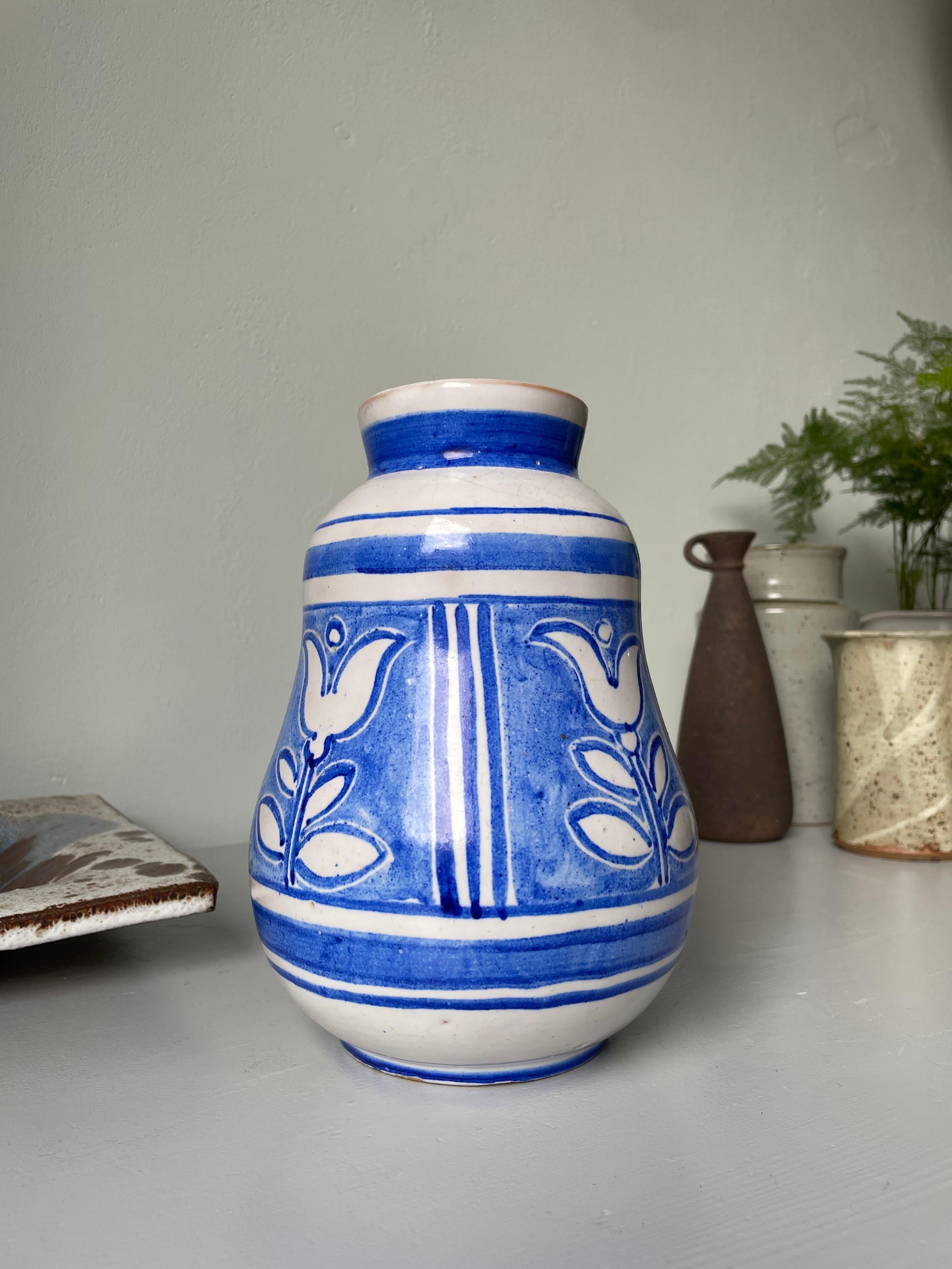 Midcentury skandinavischen modernen handgefertigten Keramik Studio weich geformte Vase. Weißer Sockel mit handgemaltem, gefüttertem Dekor mit großen weißen, blau umrandeten Blumen. Unter dem Sockel signiert. Schöner Vintage-Zustand. 
Skandinavien,