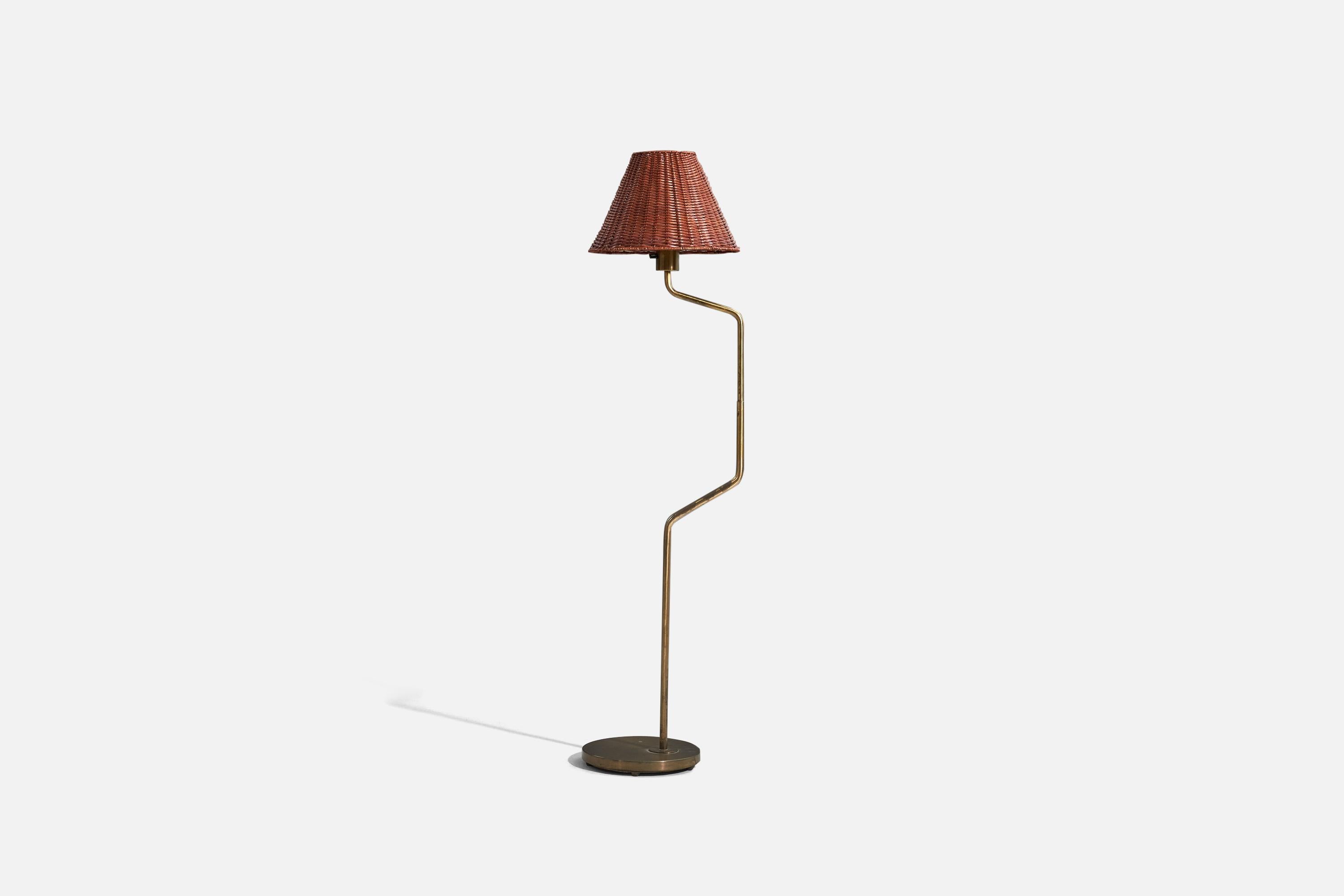 A brass and rattan floor lamp designed and produced by Nordiska Kompaniet, Sweden, 1950s. 

Sold with Lampshade. 
Stated dimensions refer to the Floor Lamp with the Shade.