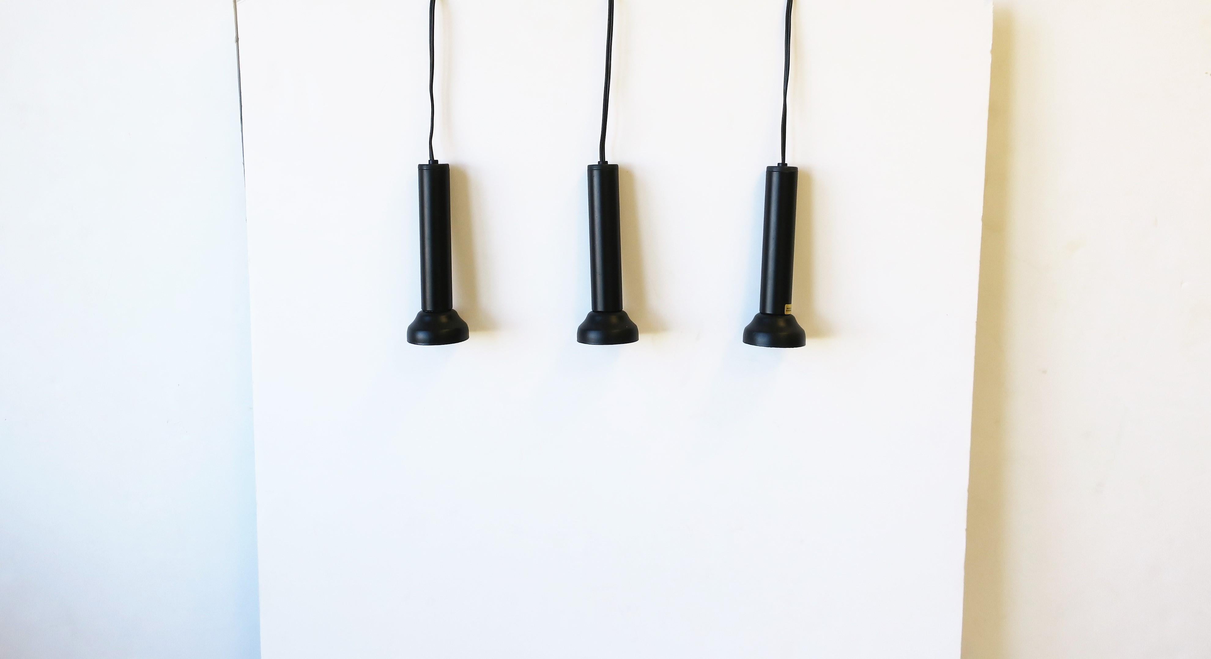 A set of three (3) Danish Postmodern pendant lights in black matte enamel by NordLux, circa late-20th century, Denmark. Each are marked 