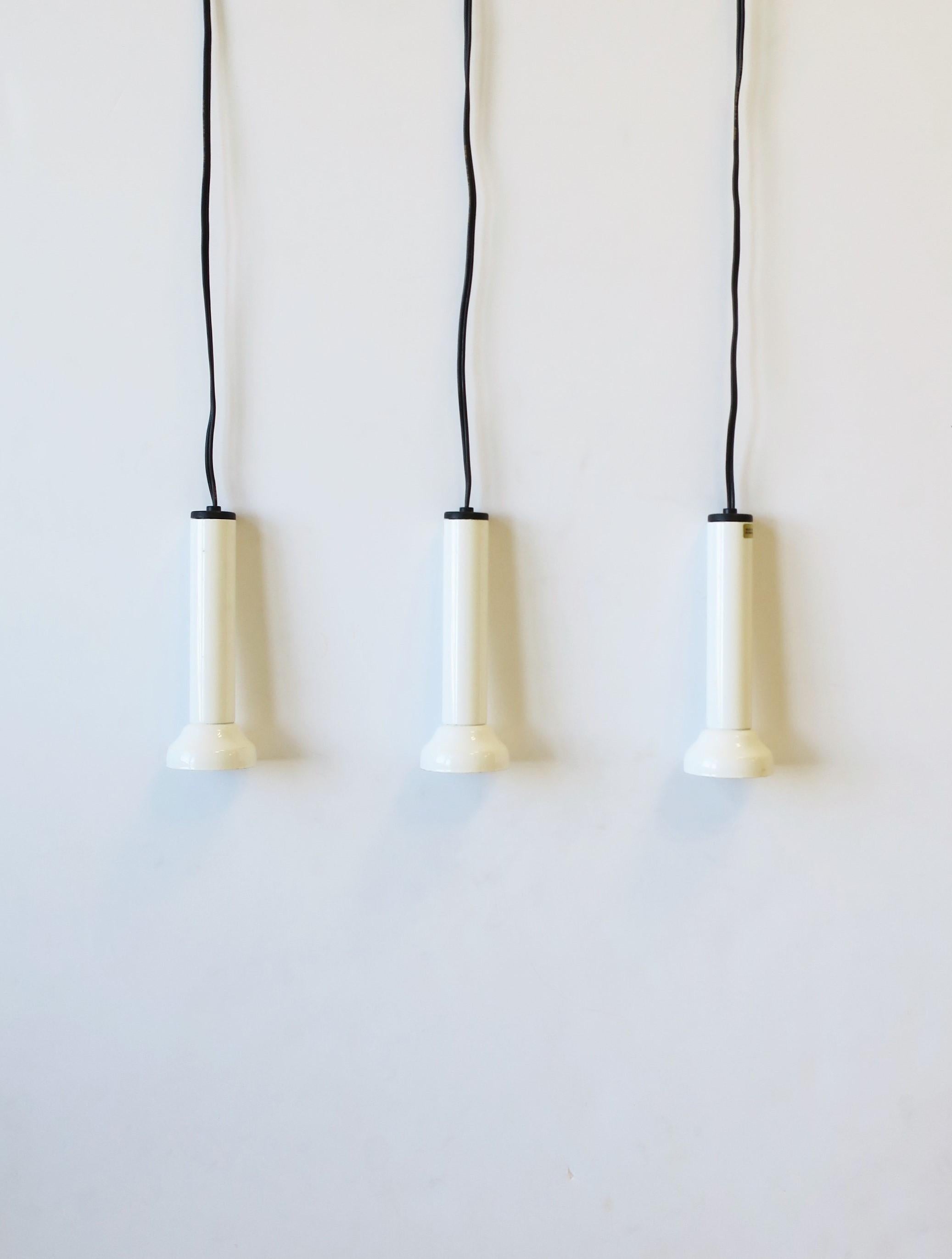 A set of three (3) Danish Postmodern pendant lights in white gloss enamel by NordLux, circa late-20th century, Denmark. Each are marked 