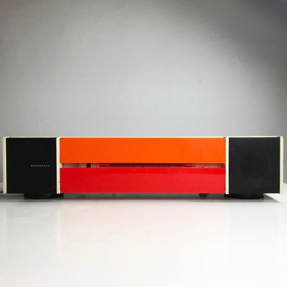 A cooperation between renowned designer Raymond Loewy and Nordmende led to this iconic radio Spectra Futura in 1968. 

A distinguished design with both orange and red acrylic front which hides the radio mechanism. 

The radio panel has pantone
