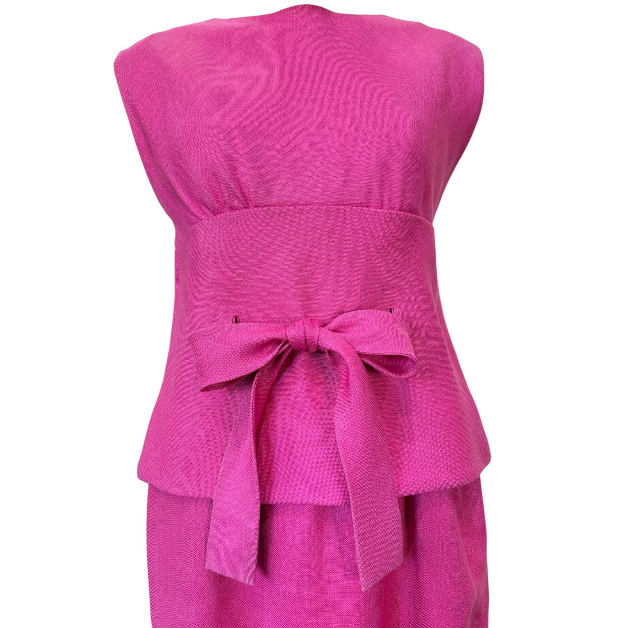 Jolie petite robe d'été des années 60 du célèbre designer américain Norman Norells. Lin rose audacieux avec un nœud à la taille. Le nœud est fixé à la robe intérieure et se tire à travers le chemisier extérieur pour sceller la silhouette. Lin léger