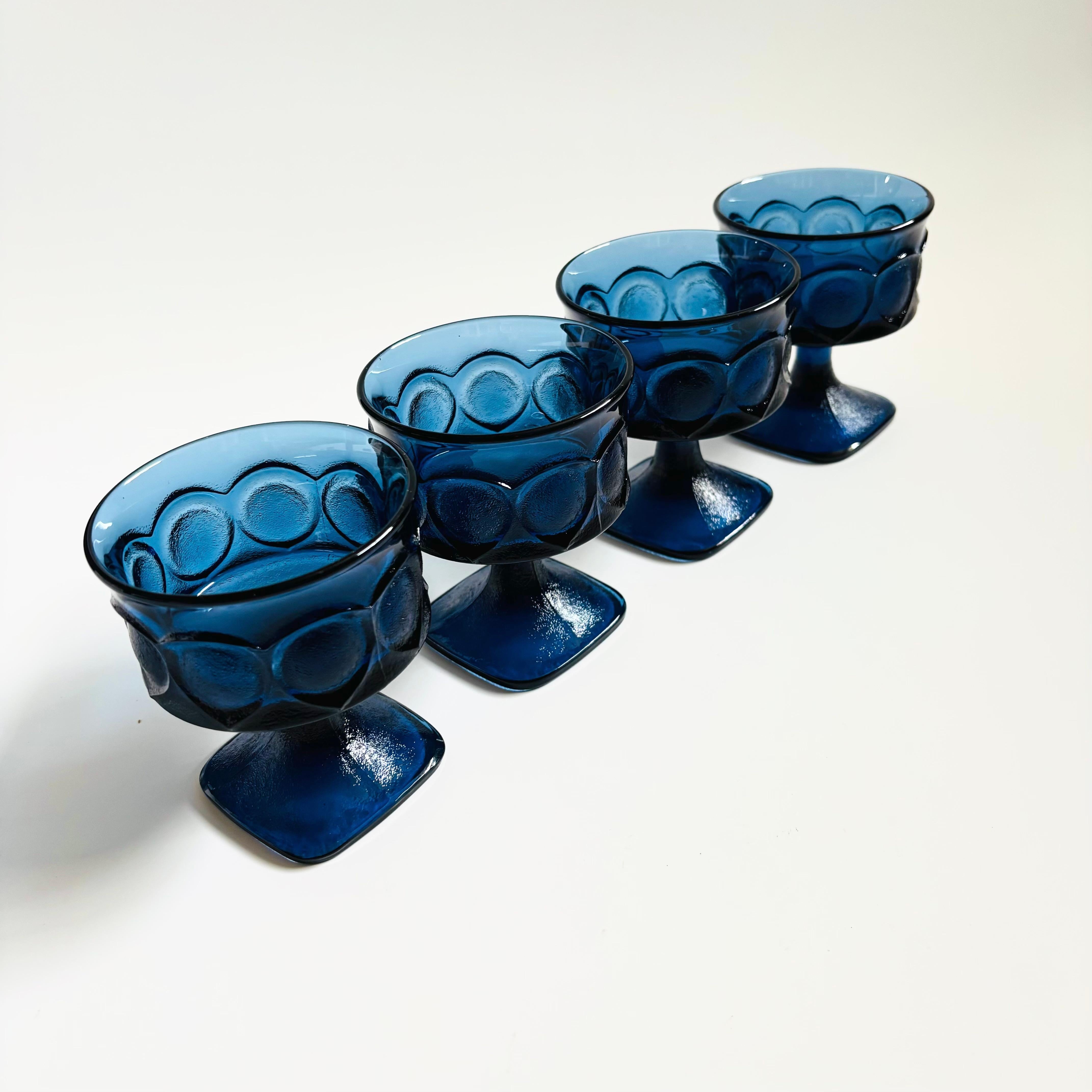 A set of 4 vintage coupe glasses in beautiful dark blue glass. Lovely textured ornate pattern to the exterior with smooth interiors. Made in the 