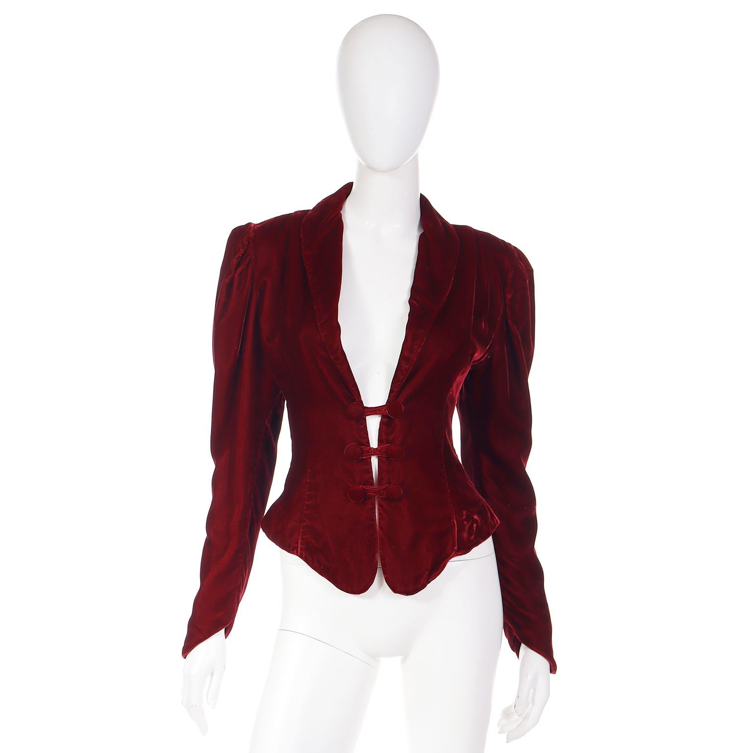 When we find vintage Norma Kamali pieces like this one, we have a hard time selling them! This gorgeous luxe deep red velvet long sleeve cropped jacket has a plunging neckline and double button loop closures. This Victorian style jacket can be worn