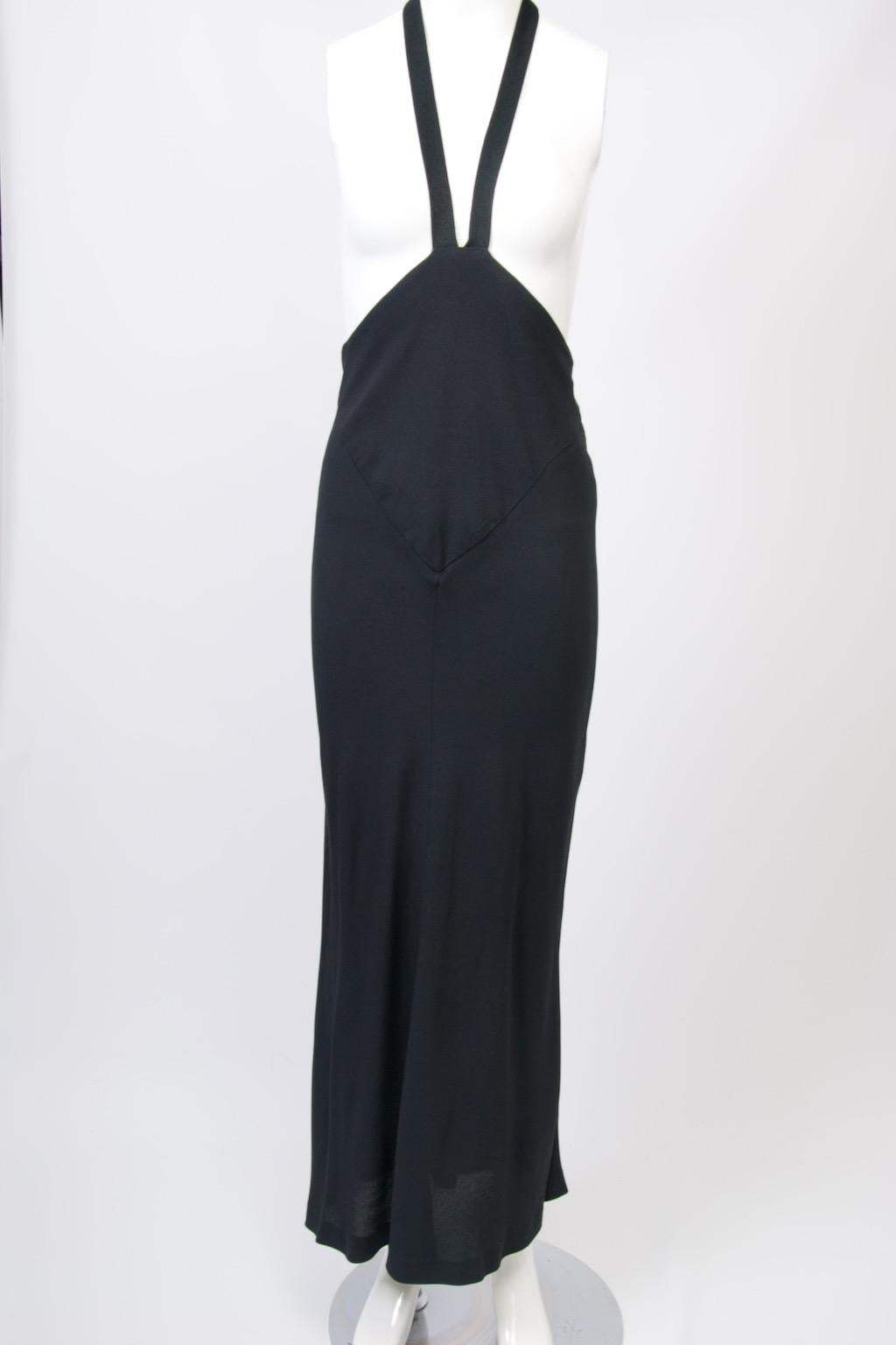 Robe longue vintage inhabituelle de Norma Kamali avec des bretelles dos nu partant d'un double empiècement triangulaire qui se rétrécit pour former une courbe basse dans le dos. Confectionnée en crêpe noir, la jupe s'ajuste aux hanches et s'élargit