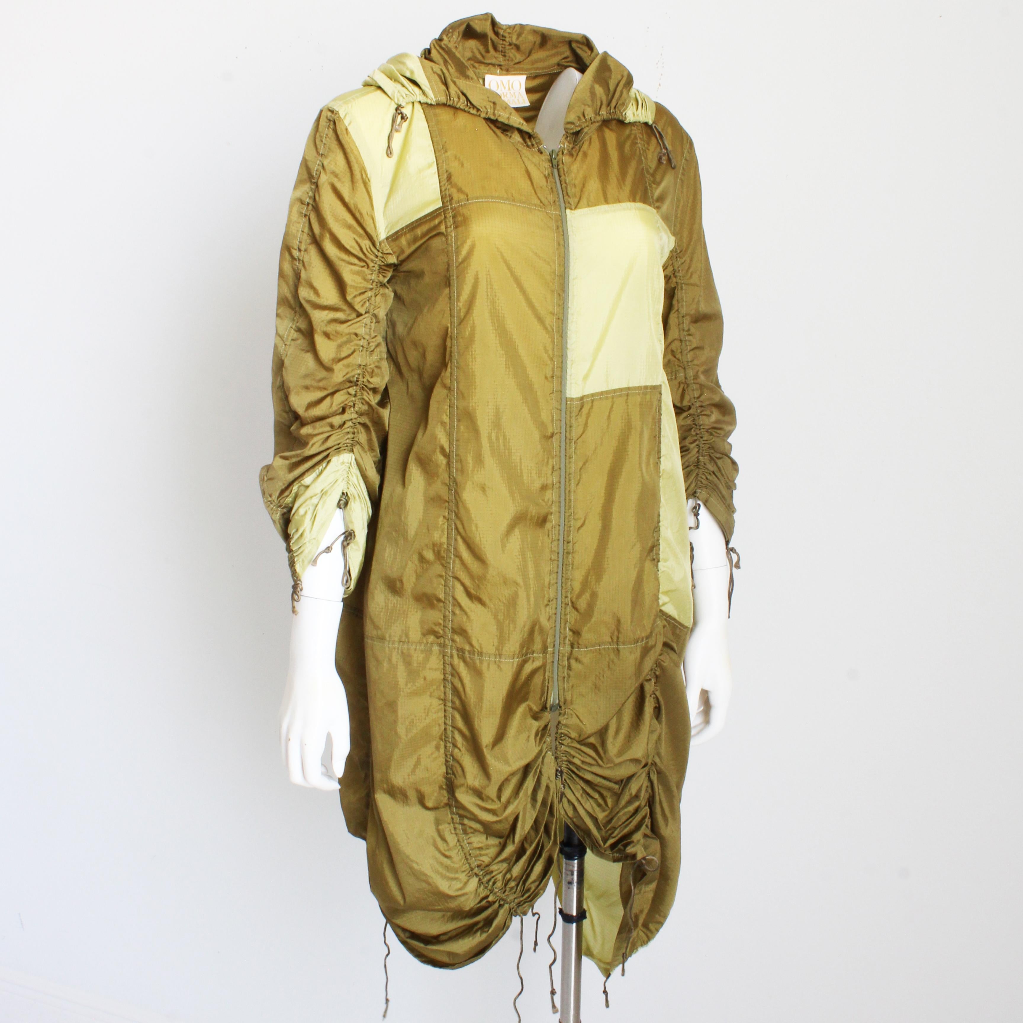 Preowned, vintage Norma Kamali parachute jacket, likely made in the early 80s.  Made from Khaki green parachute fabric with a color block pattern of tan, it features vertical silken cords throughout, allowing one to scrunch, gather and adjust the