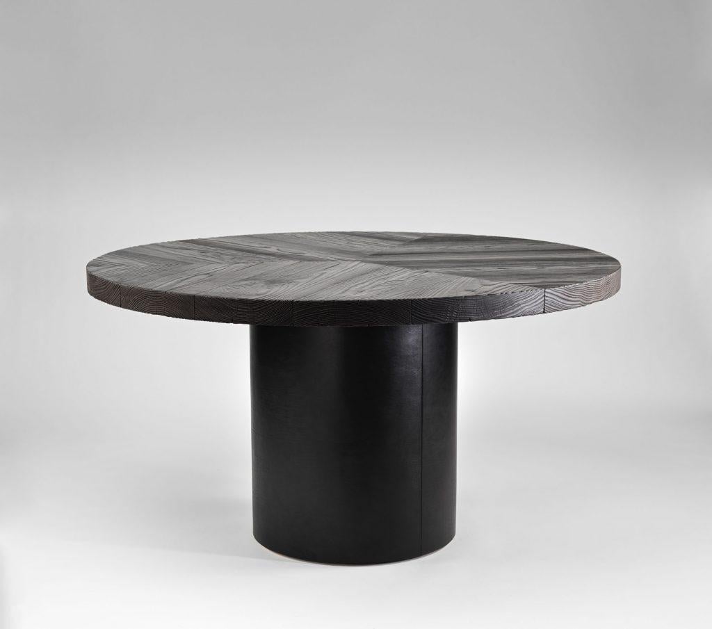 Norma table by Tim Vranken
Materials: Yellow pine burned, black leather
Dimensions: D 140 x H 75 cm

Tim Vranken is a Belgian furniture designer who focuses on solid, handmade furniture. Throughout his designs the use of pure materials and