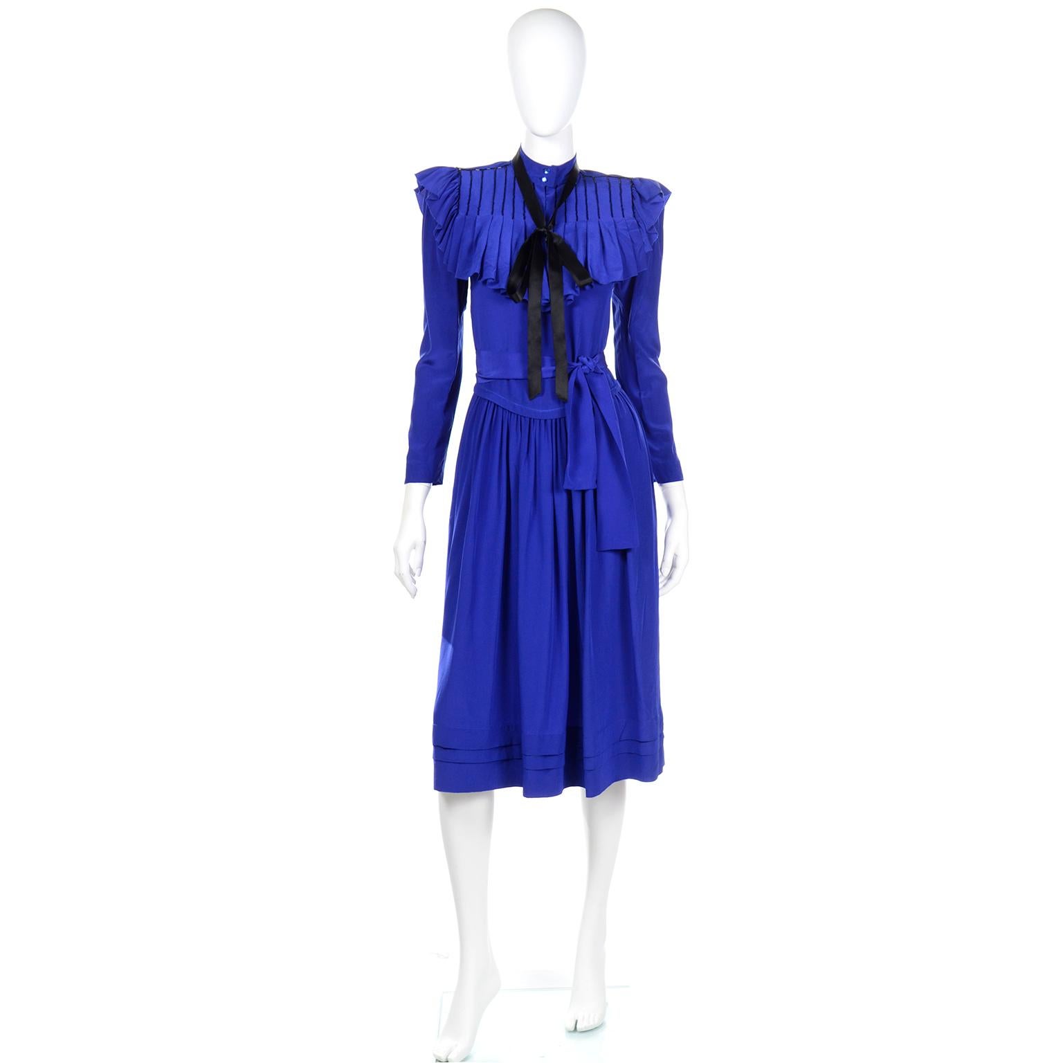 We love vintage Norma Walters pieces. Many of our finest estates have her pieces in their collections. This dress is in a blue silk with detachable beaded collar with a black silk tie.  The dress has shoulder pads,side slit pockets, and closes with