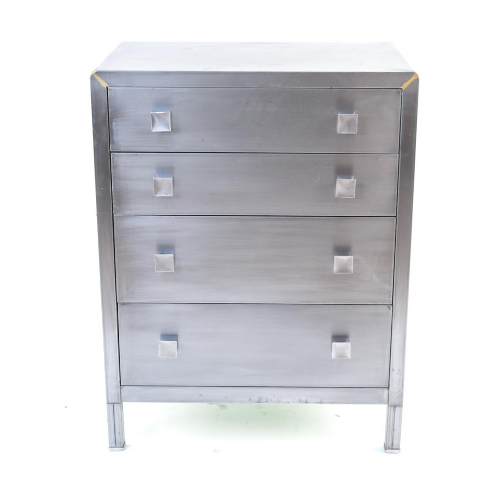 This Industrial style four-drawer metal chest of drawers was designed by Norman Bel Geddes for Simmons in the 1930s. This Art Deco, machine age design was considered avant-garde when first offered, and remains current and relevant today. This chest