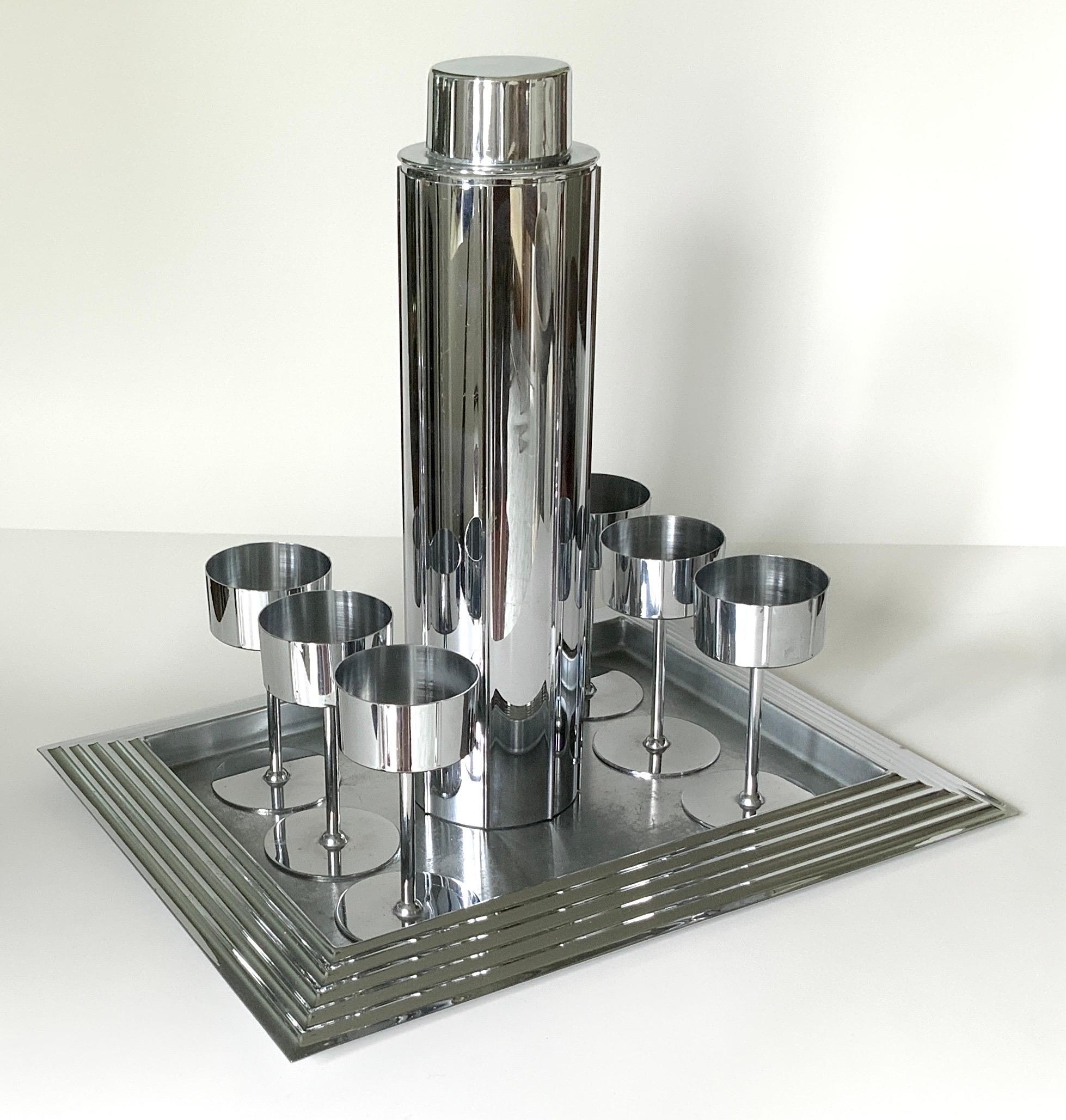 Extremely rare eight piece set of Manhattan cocktail barware designed by Norman Bel Geddes, an Icon of Revere Art Deco Revere Copper and Brass Company. The ultimate chrome & brass complete set, circa 1936. Signed on the bottom. 
The tray measures