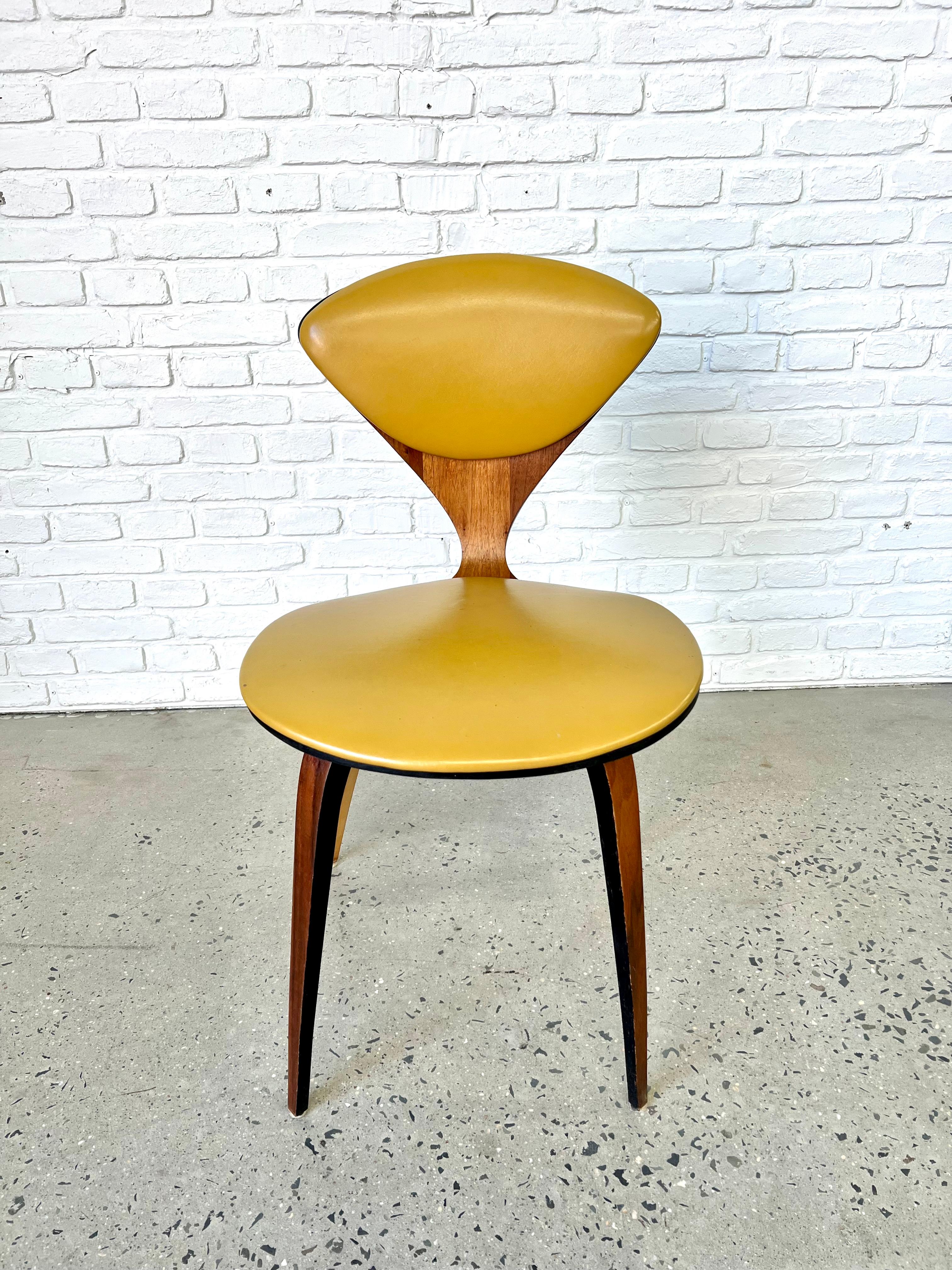 Chaise en contreplaqué courbé avec coussin en vinyle jaune (Naugahyde) datant des années 1960 et réalisée par le designer Norman Cherner pour Plycraft.  À l'origine, cette chaise aurait été utilisée comme chaise de salle à manger dans un ensemble,