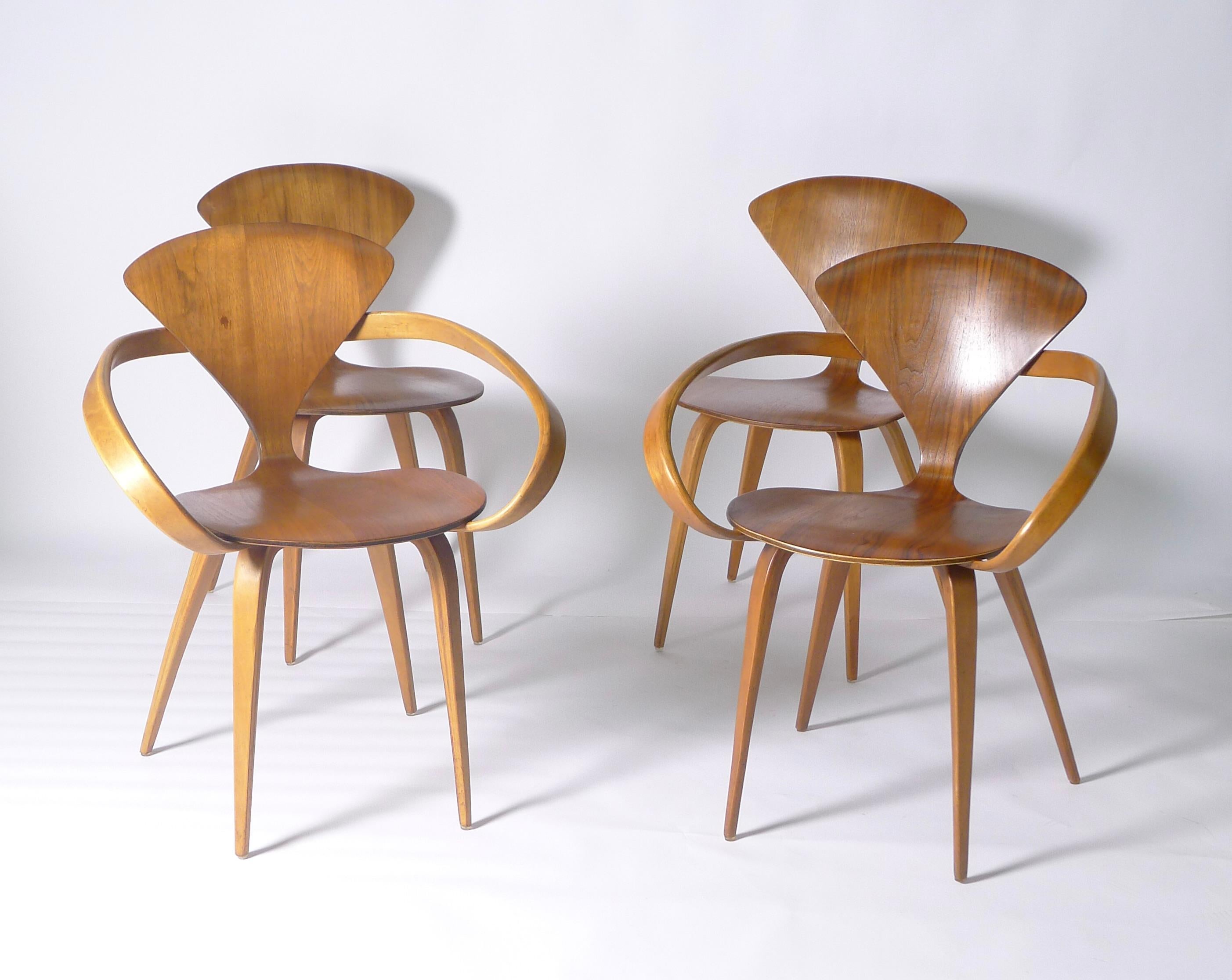 Norman Cherner's 1958 'wasp-waisted' moulded plywood chair is an icon of mid-century furniture design. 

This set of eight original Norman Cherner dining chairs, was made by Plycraft, USA, in the late 1950s, and comprises six single chairs and two