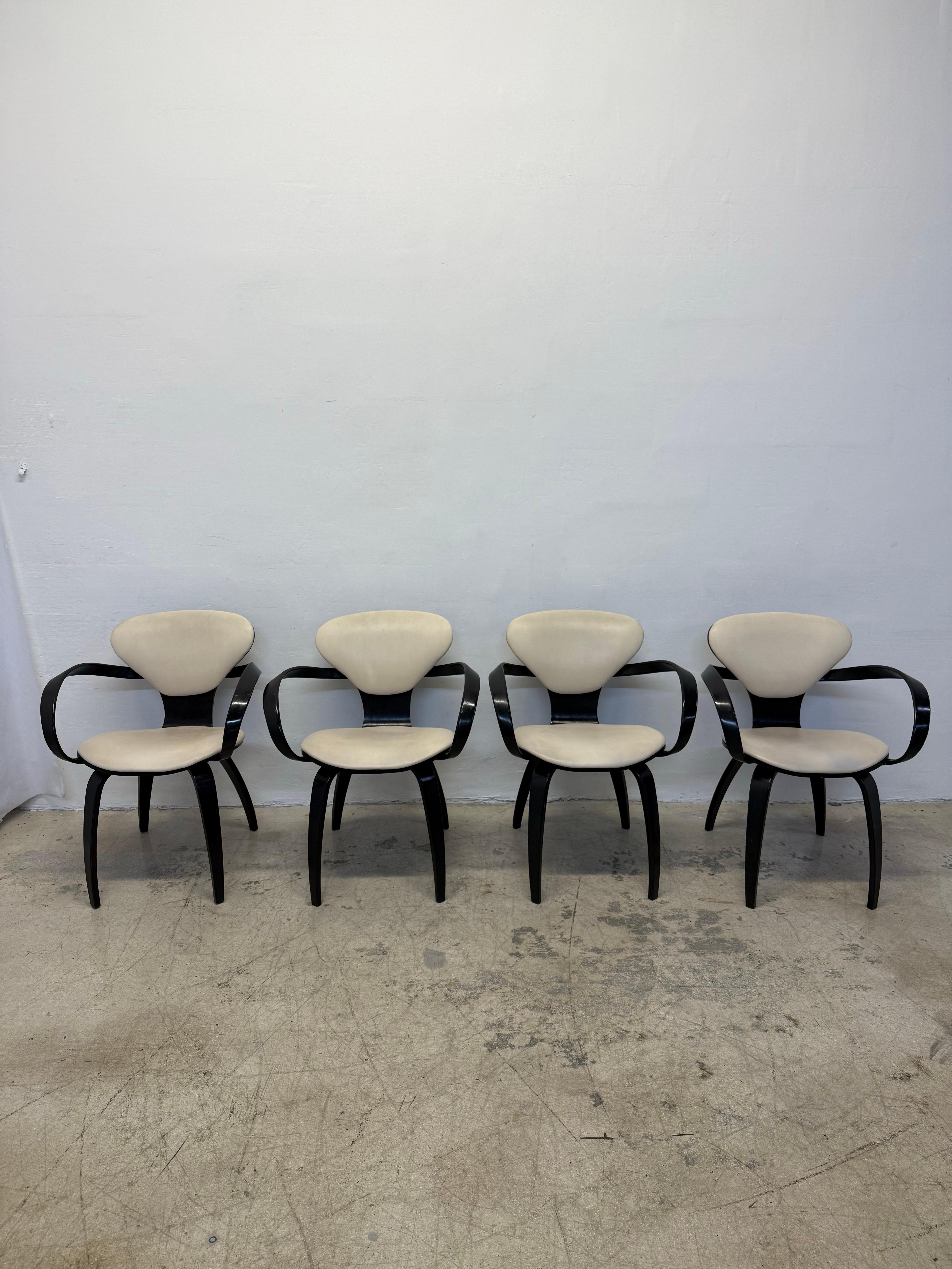 Set of four early edition Cherner Pretzel chairs originally designed to by Norman Cherner for Plycraft.  The lightweight molded plywood is ebonized and the seats and backs are a cream color eco leather.