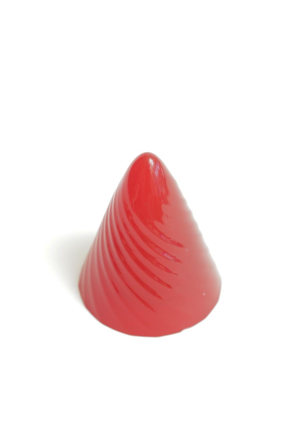 This wonderful Norman Mercer red Lucite conical form sculpture paperweight is from the 1990s. It has textural spirals. He was an engineer turned artist from NYC. His major lucite sculptures are very coveted as he is no longer living. The original