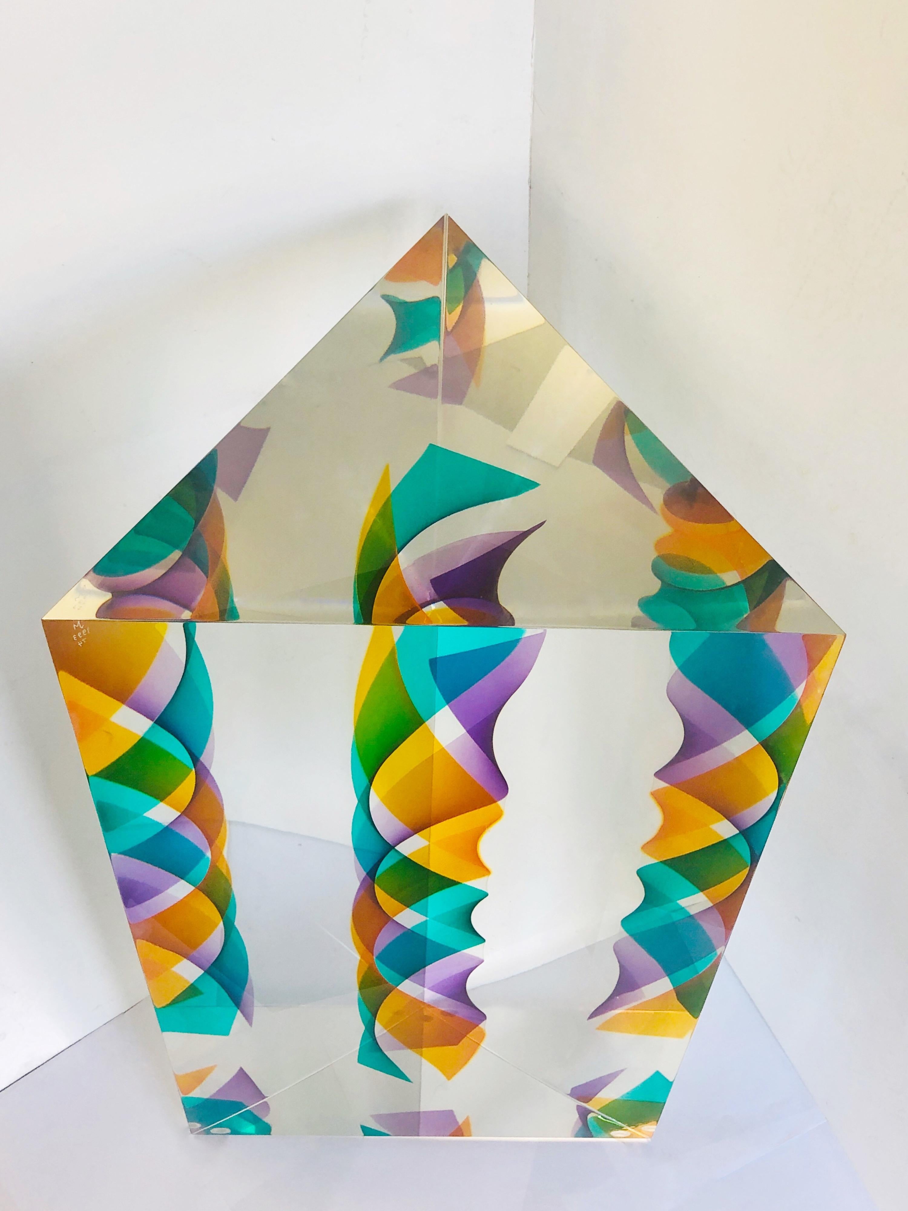 A monumental Lucite sculpture by Norman Mercer. A solid Op Art monolithic triangular sculpture. There is a colorful spiral at the center that appears to multiply when seen from different angles. Each side is 16.5