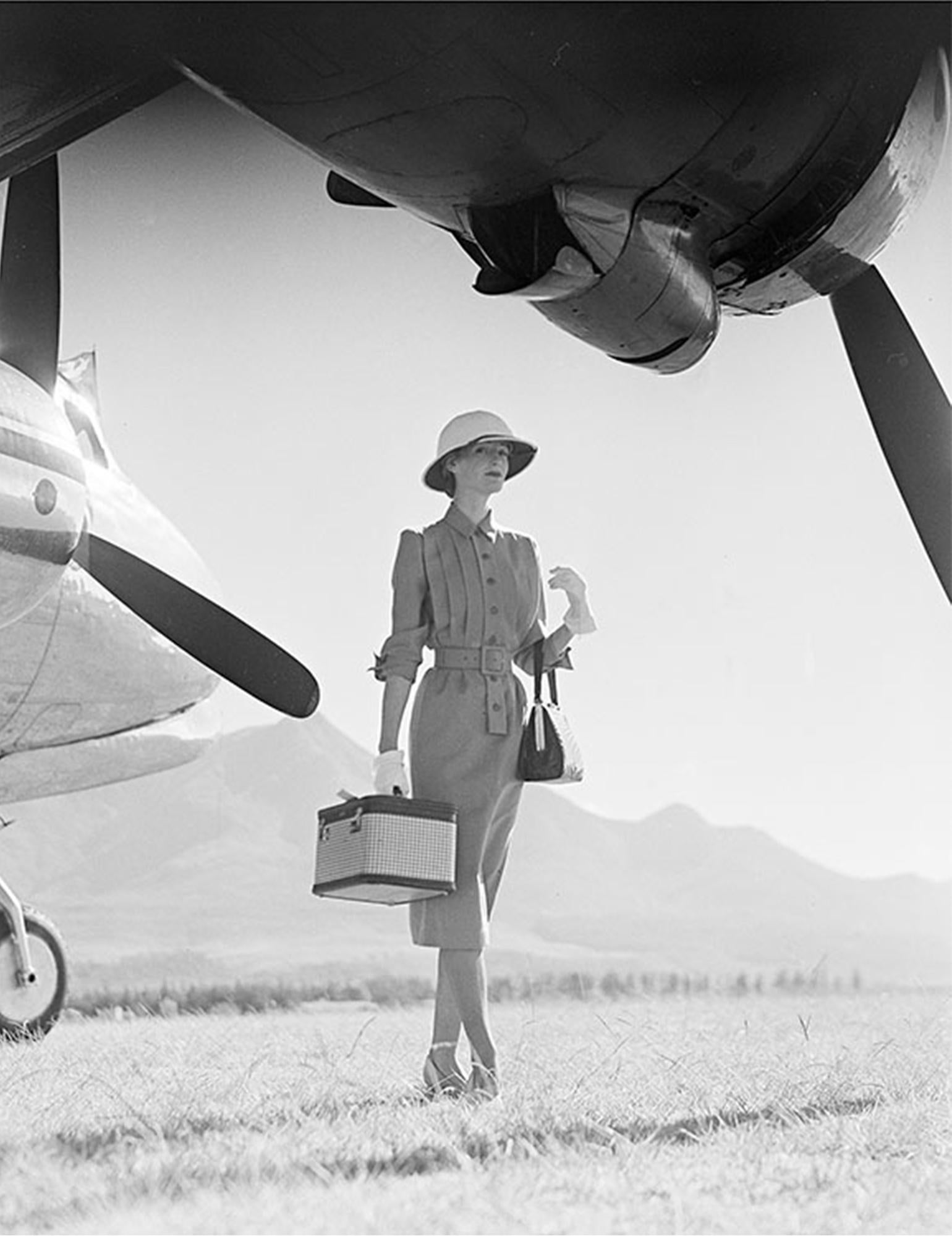 British fashion model Wenda Parkinson wearing a grey gabardine dress by Dorville at George Airfield in Nairobi, Kenya, South Africa, next to a Hermes airplane for British Vogue, May 1951.

NORMAN PARKINSON POSTHUMOUS LIMITED EDITION PRINTS 

ALL