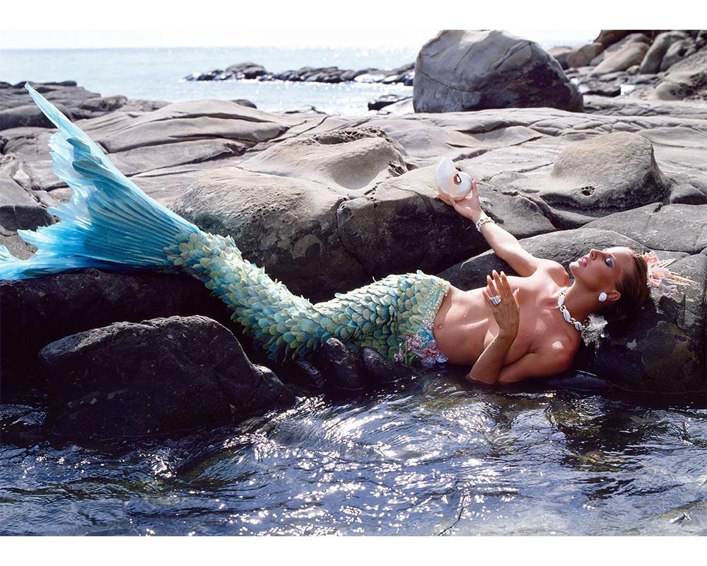 Deborah Harris wird im Februar 1990 vor Ort in Malaysia in einem von Bob Mackie für Townes & Country entworfenen Meerjungfrauenschwanz fotografiert. Diese Geschichte war die letzte Aufnahme des Fotografen Norman Parkinson.

Deborah Harris im Schwanz