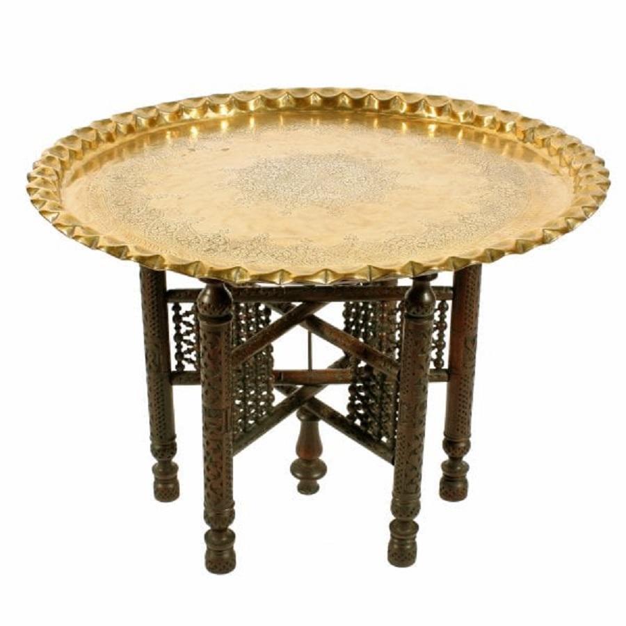 An early 20th century North African circular brass tray top table.

The large tray top has engraved decoration and a very nice raised shaped rim.

The tray top stands on a folding stand that has six legs with a bobbin turned frame and folds