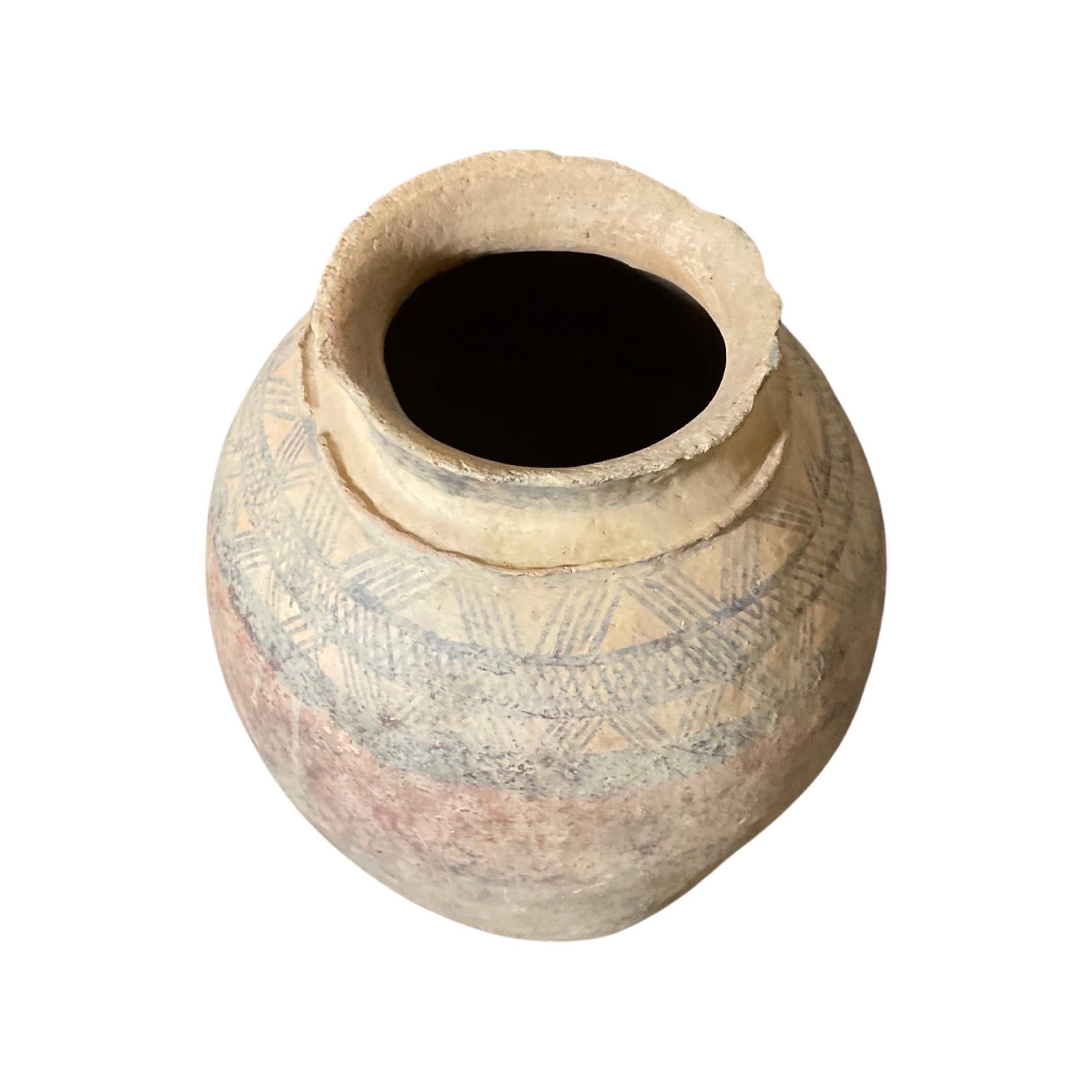 This antique North African terracotta vessel is a rare find, complete with a sturdy base holder for added stability. Its faded and unique African-inspired designs, dating back to the mid-1800s, add character and charm to any collection. Crafted
