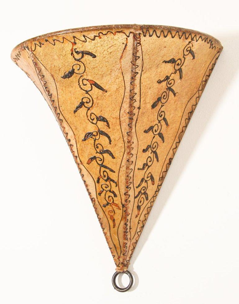 Afrikanische Stammeskunst aus Pergament mit einer großen dreieckigen Form aus Leder, die auf Eisen genäht und handbemalt ist.
Diese marokkanischen Kunstwerke können als Lampenschirm für die Wand verwendet werden.
Ein mit Pergament überzogener