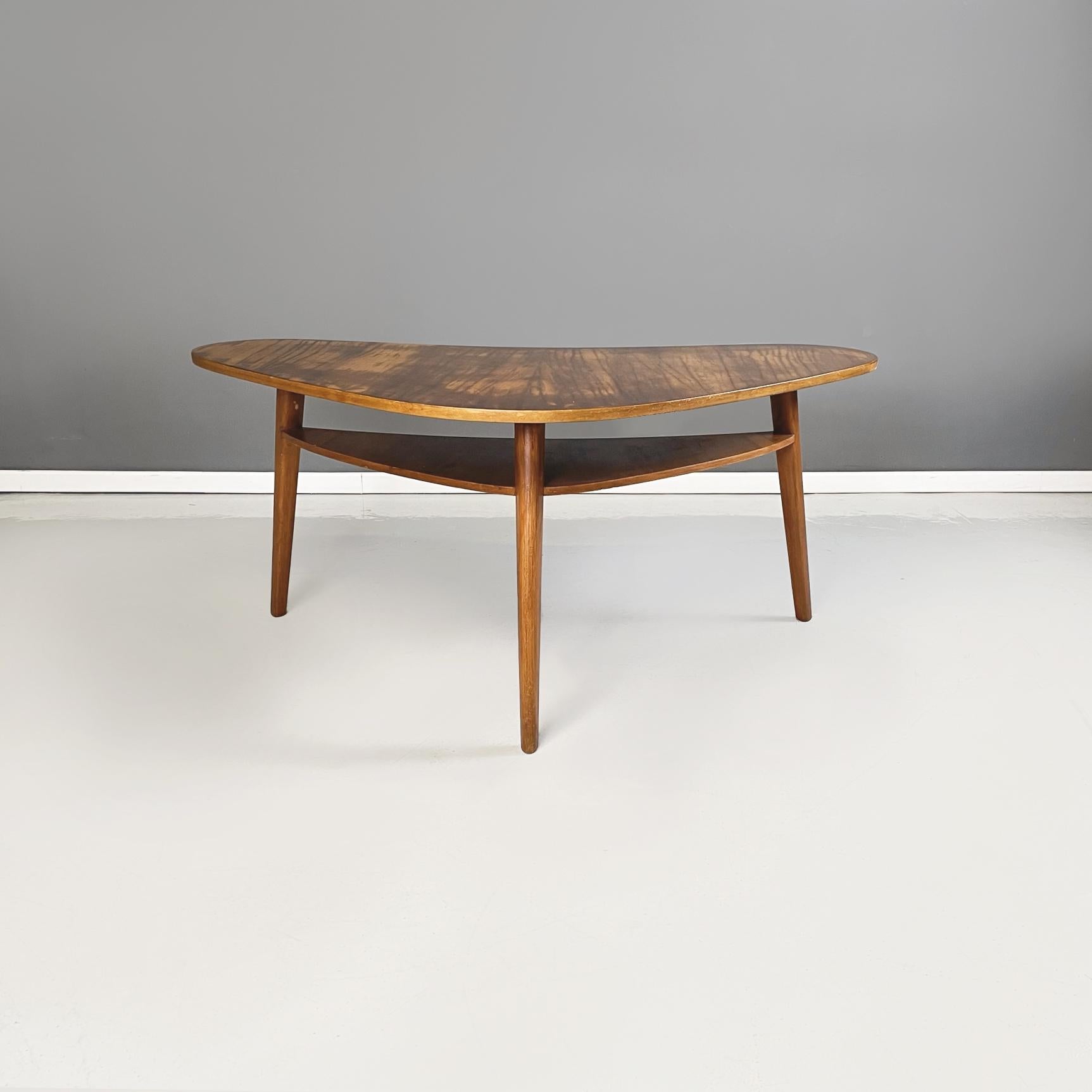 North Europa midcentury Triangular coffe table with double shelves in solid wood, 1960s
Coffee table with double top in solid wood. The larger upper top has a rounded triangular shape. The triangular shelf below is smaller in Size and connects to