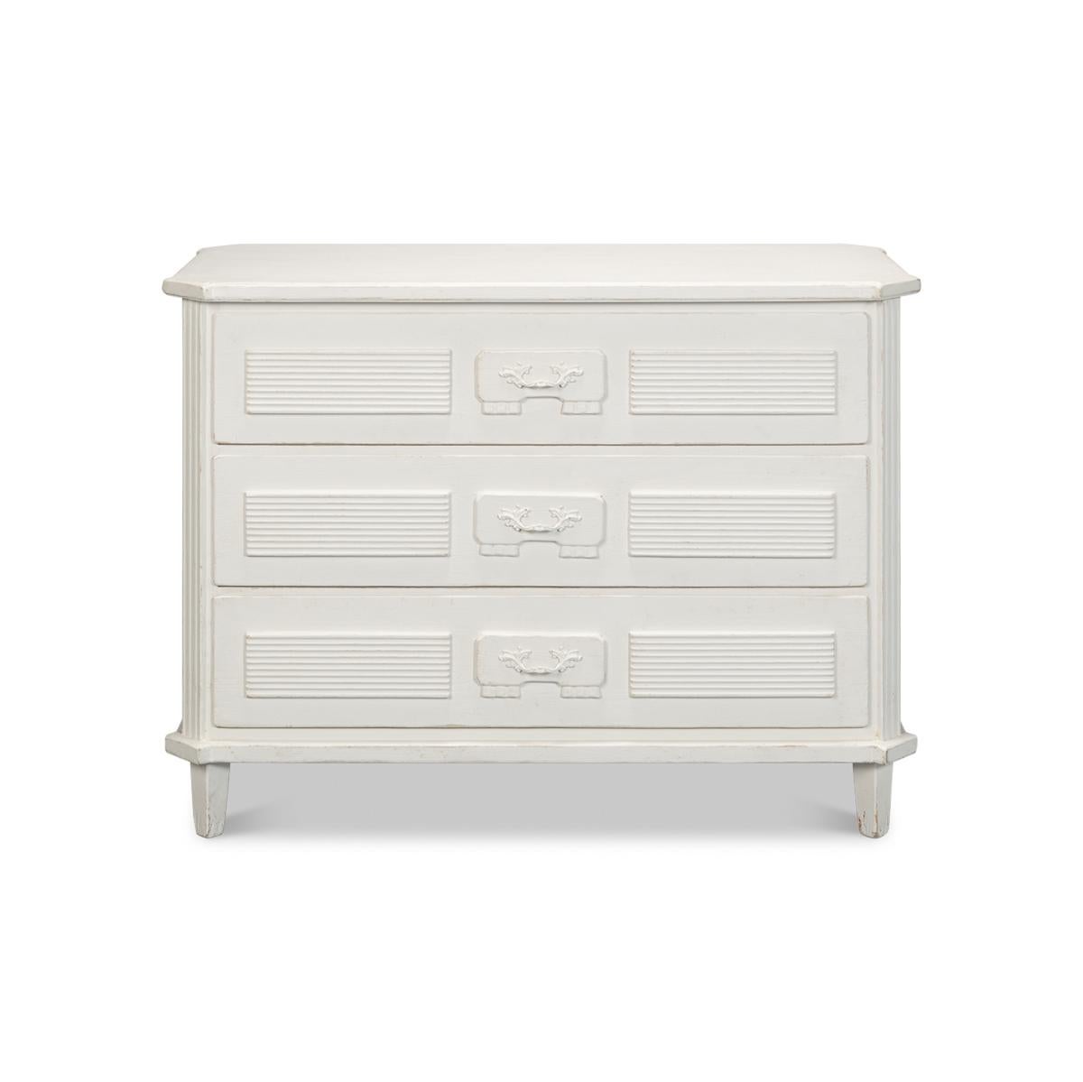 Made with reclaimed pine in an antique white hand-rubbed and distressed painted finish. The three long drawers with neo-classic motifs and canted corners with fluted styles., all raised on square tapered legs.

Dimensions: 46