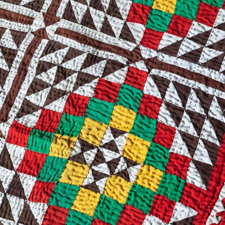 Brown and white squares with red, green, and yellow interior and a sawtooth border.
North Indian 1970s
Measures: 148 x 225cm.