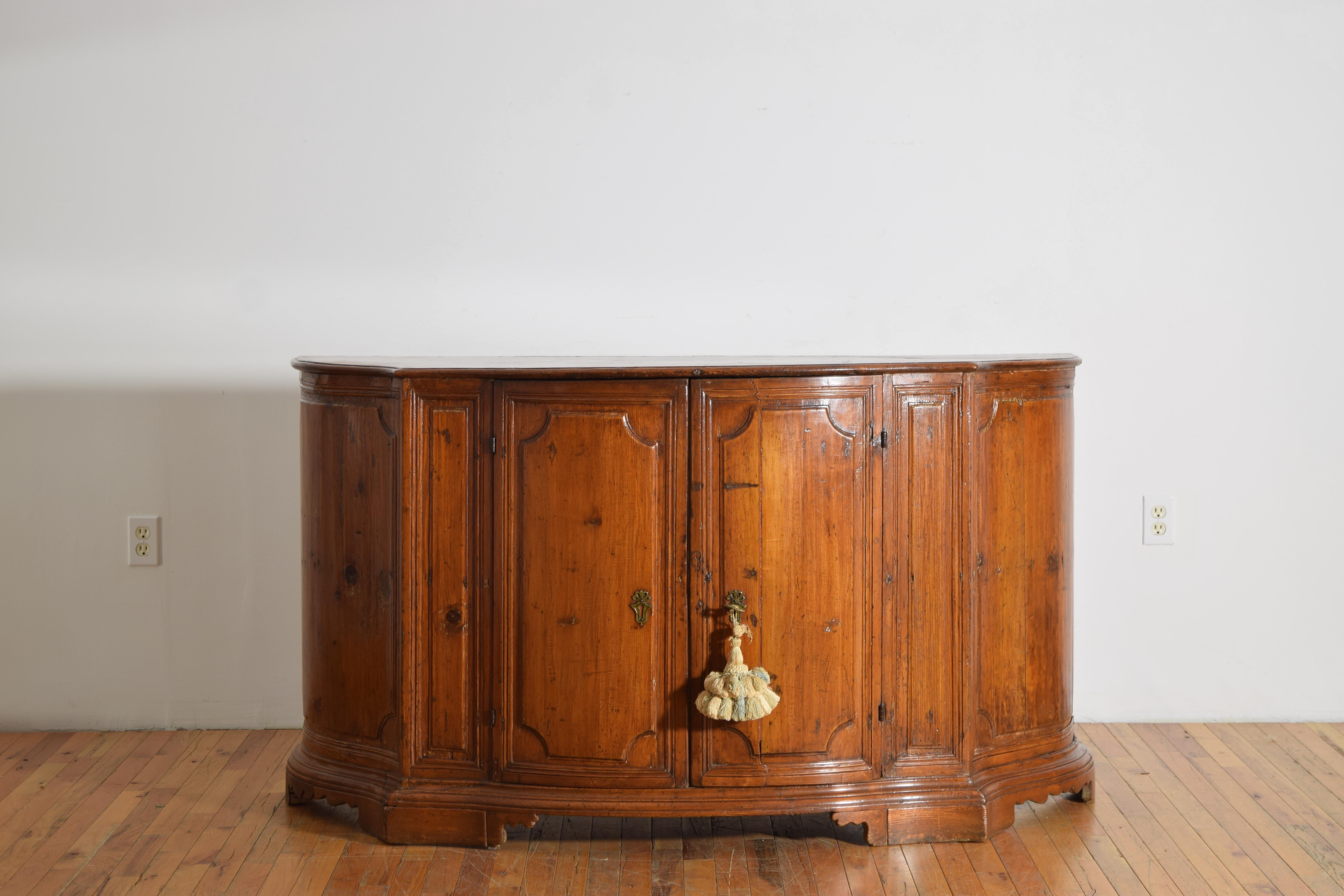 avec un plateau en forme de serpentin aux coins arrondis et au bord mouluré surmontant un boîtier conforme avec quatre portes à panneaux et des pilastres à panneaux, chaque porte s'ouvrant pour révéler des étagères intérieures, reposant sur des