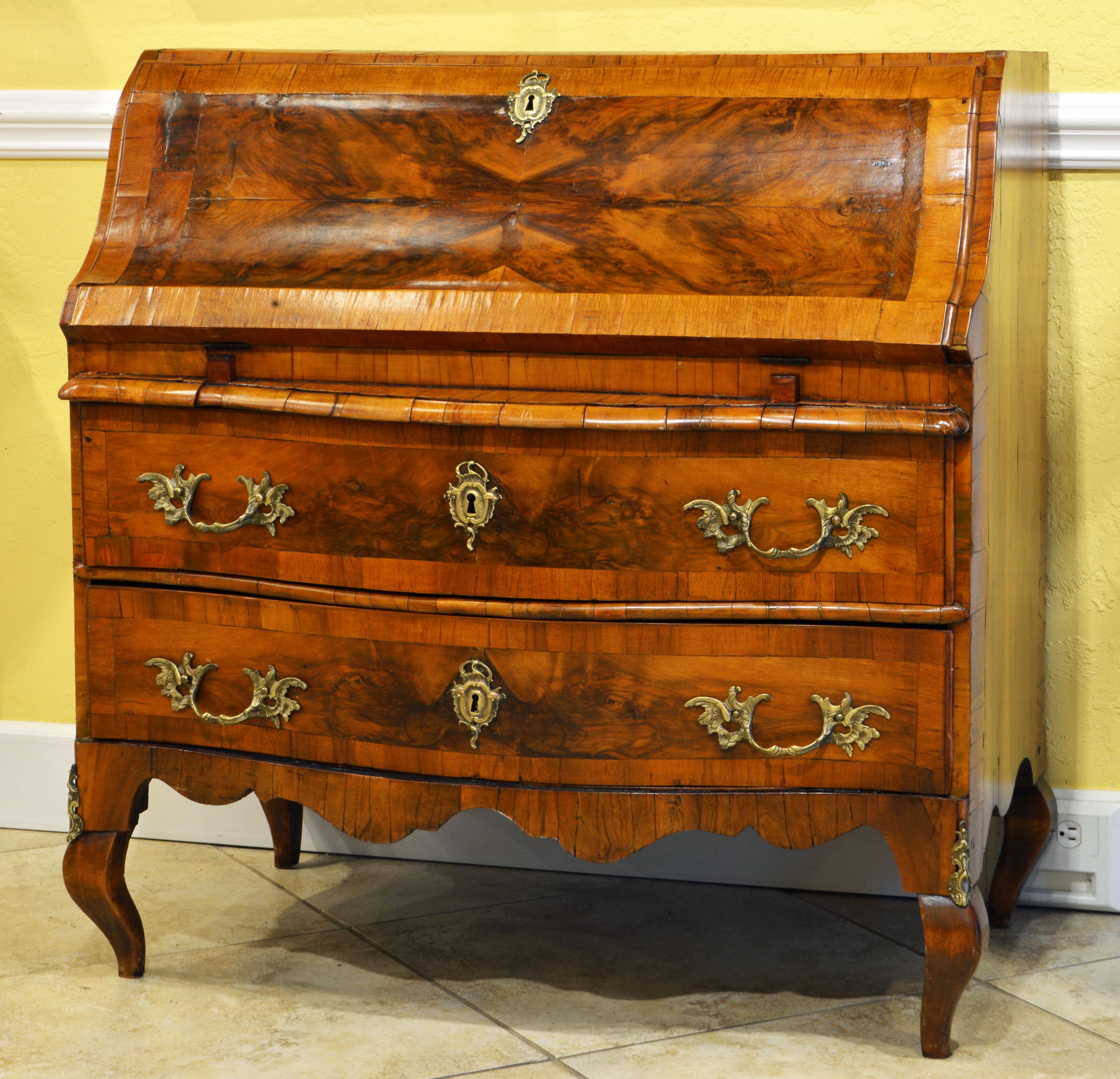 This fine North Italian Austrian inspired fall front banded walnut secretary desk features a fall front that opens up to an interior with stepped rows of short drawers, the bottom drawer being a combination making one long drawer, and a writing