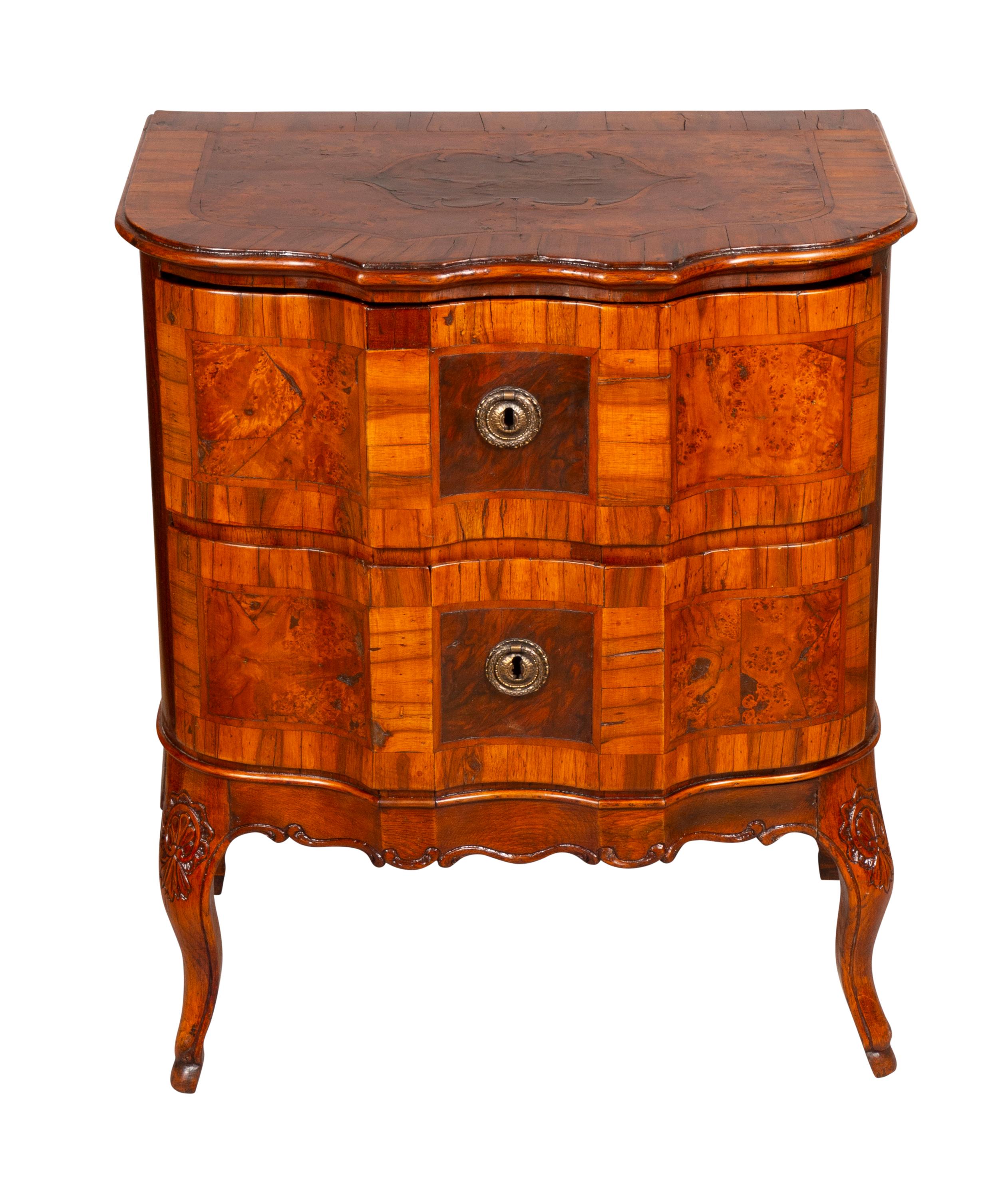Shaped top over two conforming drawers and raised on cabriole legs.