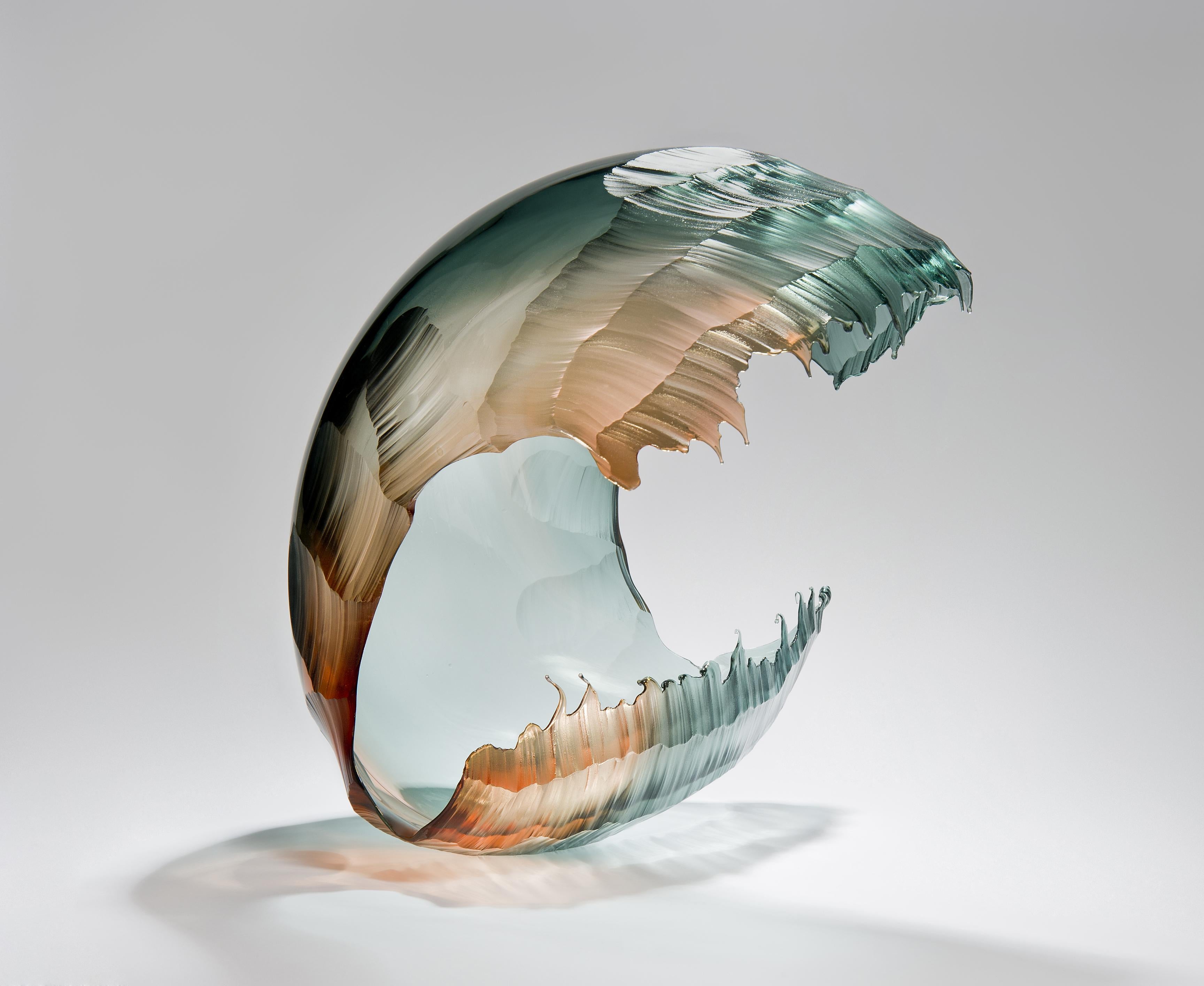 North Sea Morning Wave Form, is a unique Teal & Apricot Glass Sculpture by the British artist Graham Muir.
With his ‘Wave’ series, Muir exploits gravity and the way in which the soft, molten glass responds, no mean feat as often both this physical