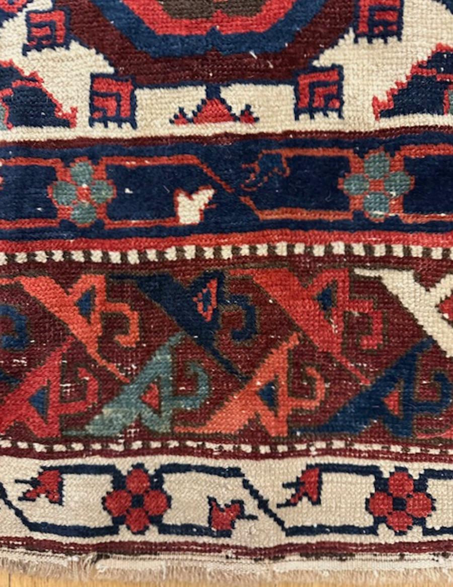 Nordwest-Perserteppich (Iran)

Alter: ca. 1850

Abmessungen: 7′.6″x3′.8″ (229×112 cm)

Das elfenbeinfarbene Feld ist mit mehrfarbigen Blättern, Palmetten, Blumen und anderen kleineren Elementen verziert, die Blätter bilden kreuzähnliche Motive, die