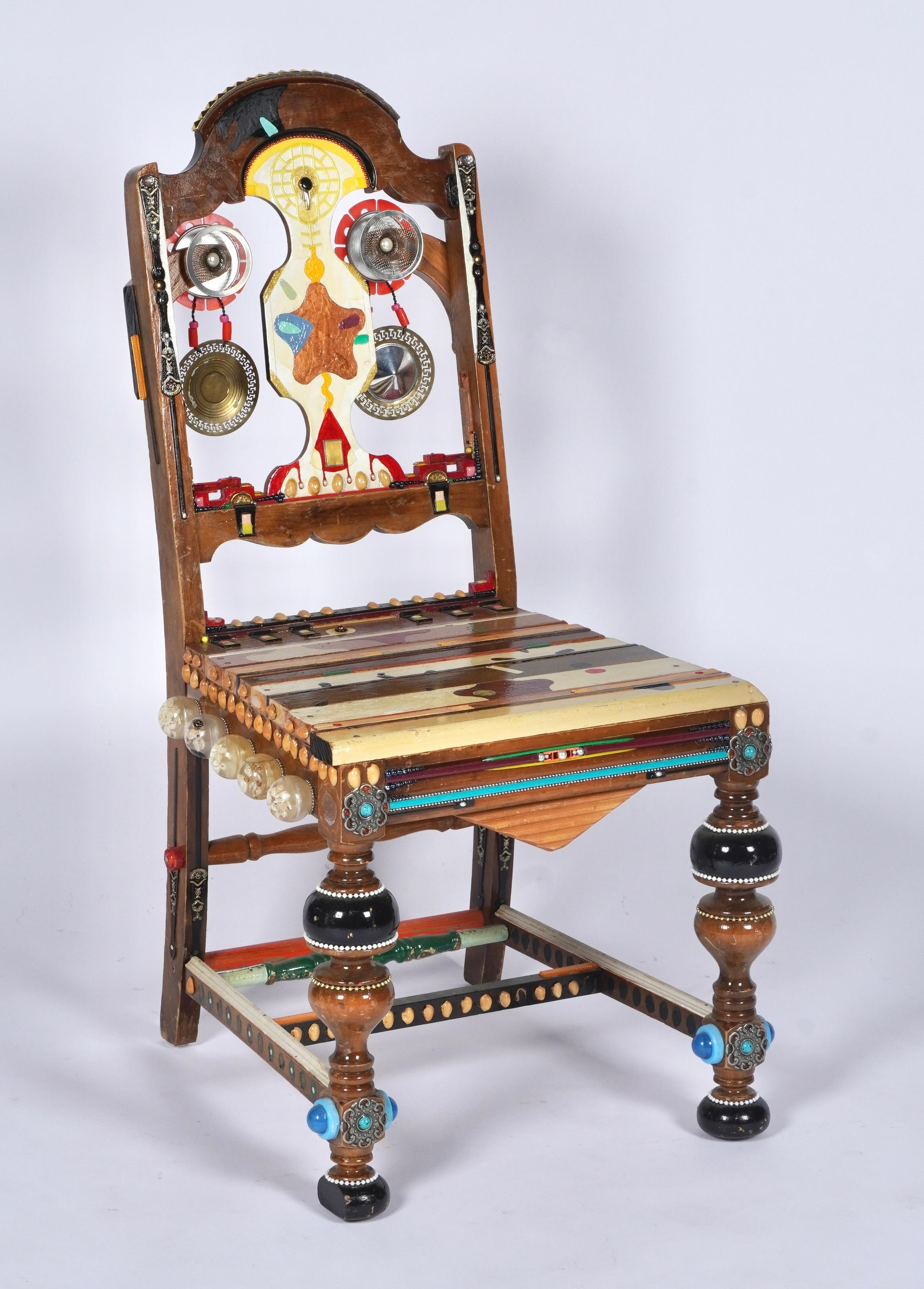 Hand crafted art chair found in a small town in Northern California created out a blend of various found materials embellished onto the chair, that being, metal, glass, mixed woods, paint, resin, shell and plastic. A whimsical play on a side chair